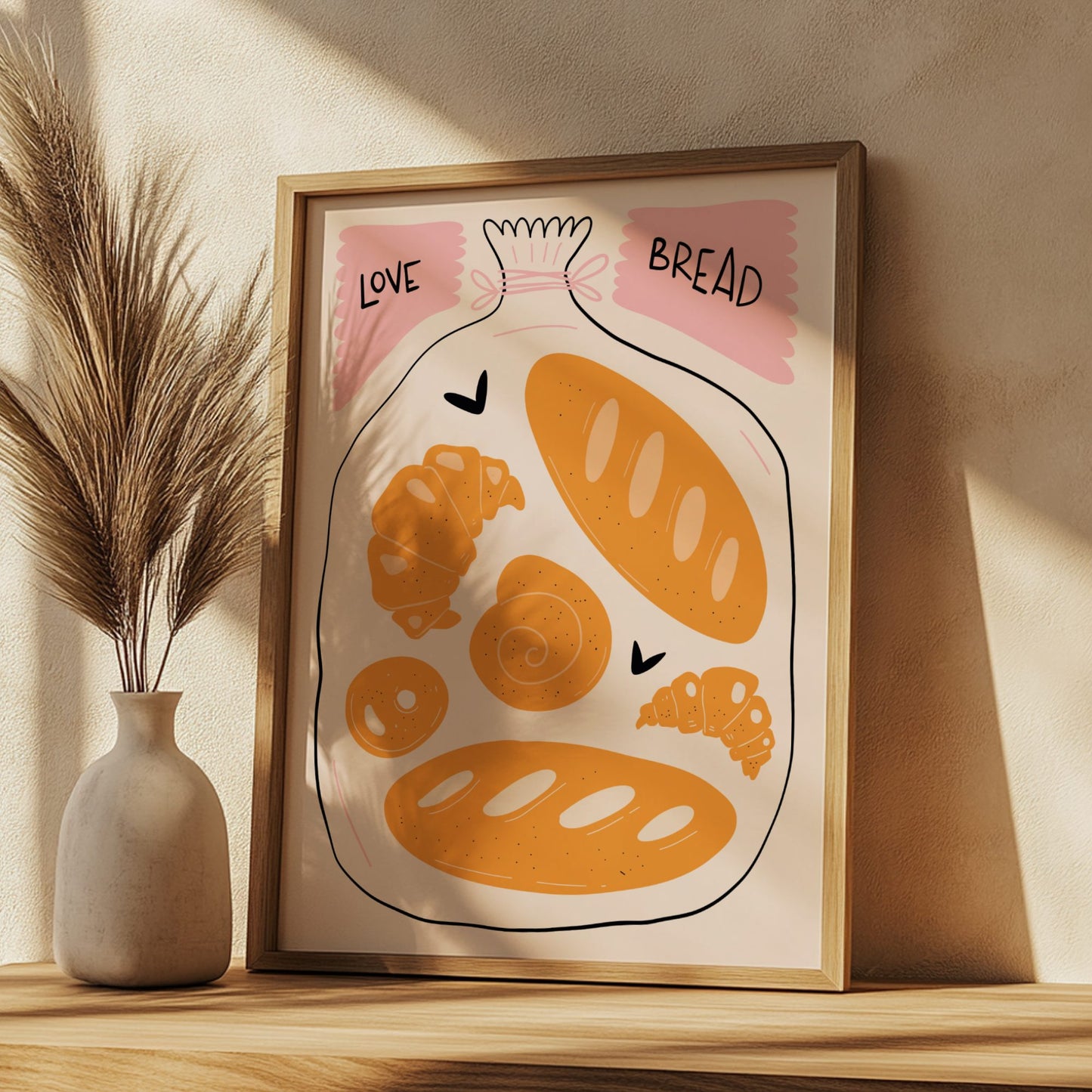 Framed illustration of bread and a bag labeled 'Love Bread' on a wooden shelf with a vase and dried plants.
