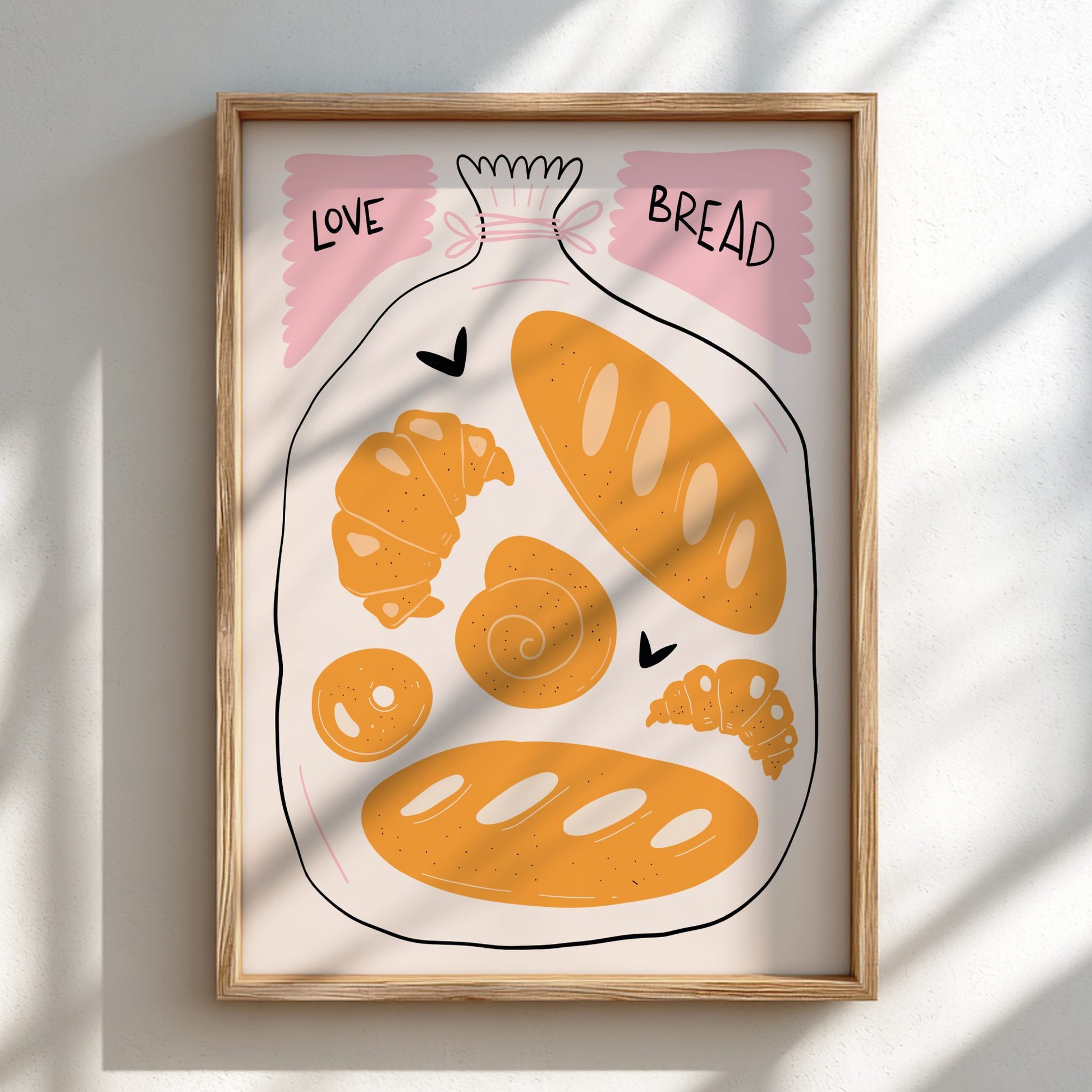 Framed artwork of bread and pastries with 'LOVE' and 'BREAD' text on a light background