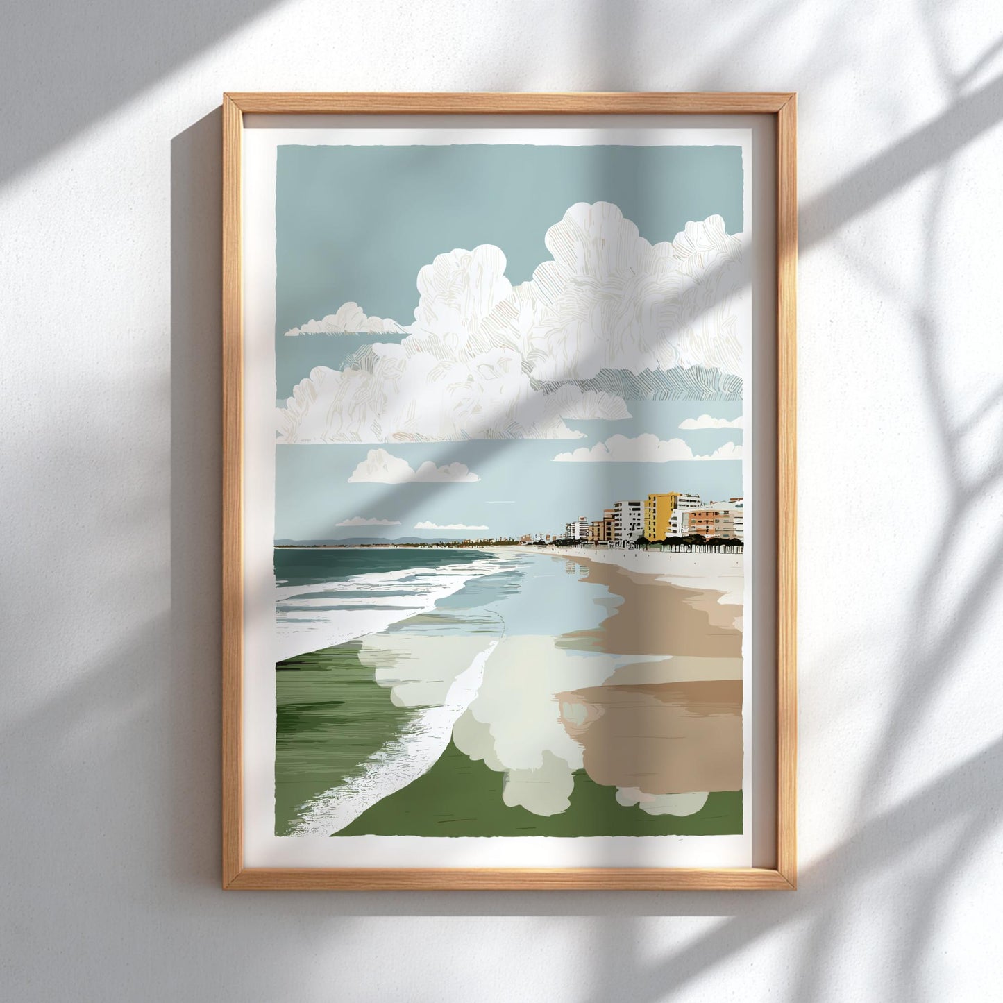 Framed artwork of a beach scene with a blue sky, white clouds, green grass, and a path.