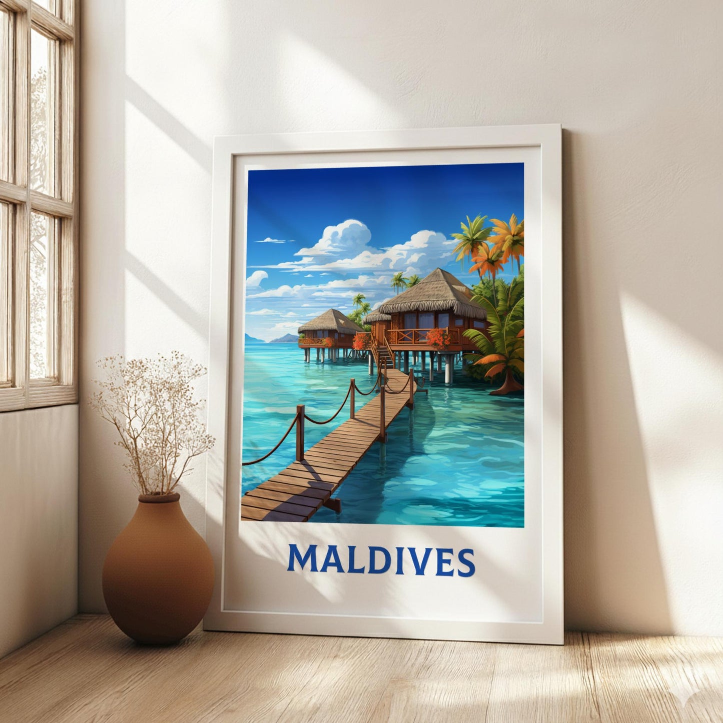 Framed artwork of the Maldives with a wooden dock and tropical houses, placed on a light wooden floor.