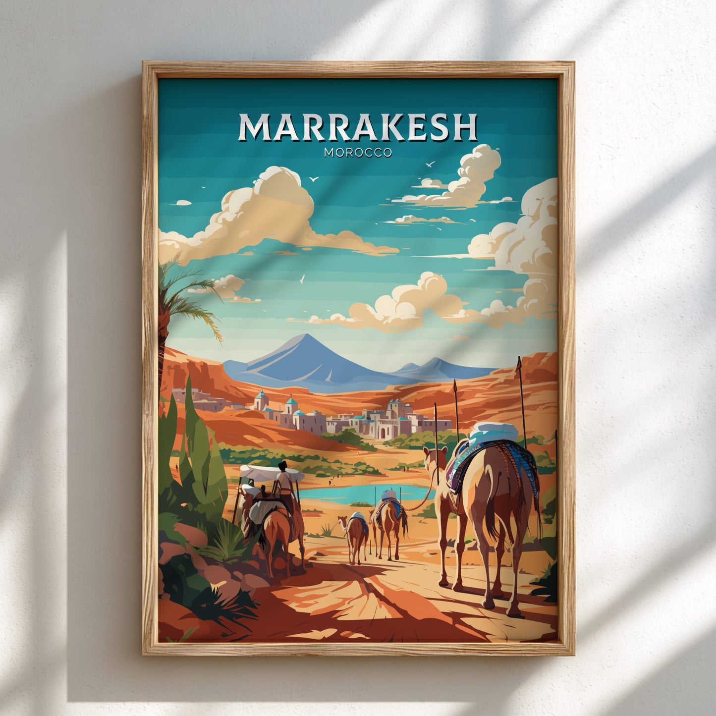 Framed artwork of Marrakesh with camels and mountains on a blue sky background
