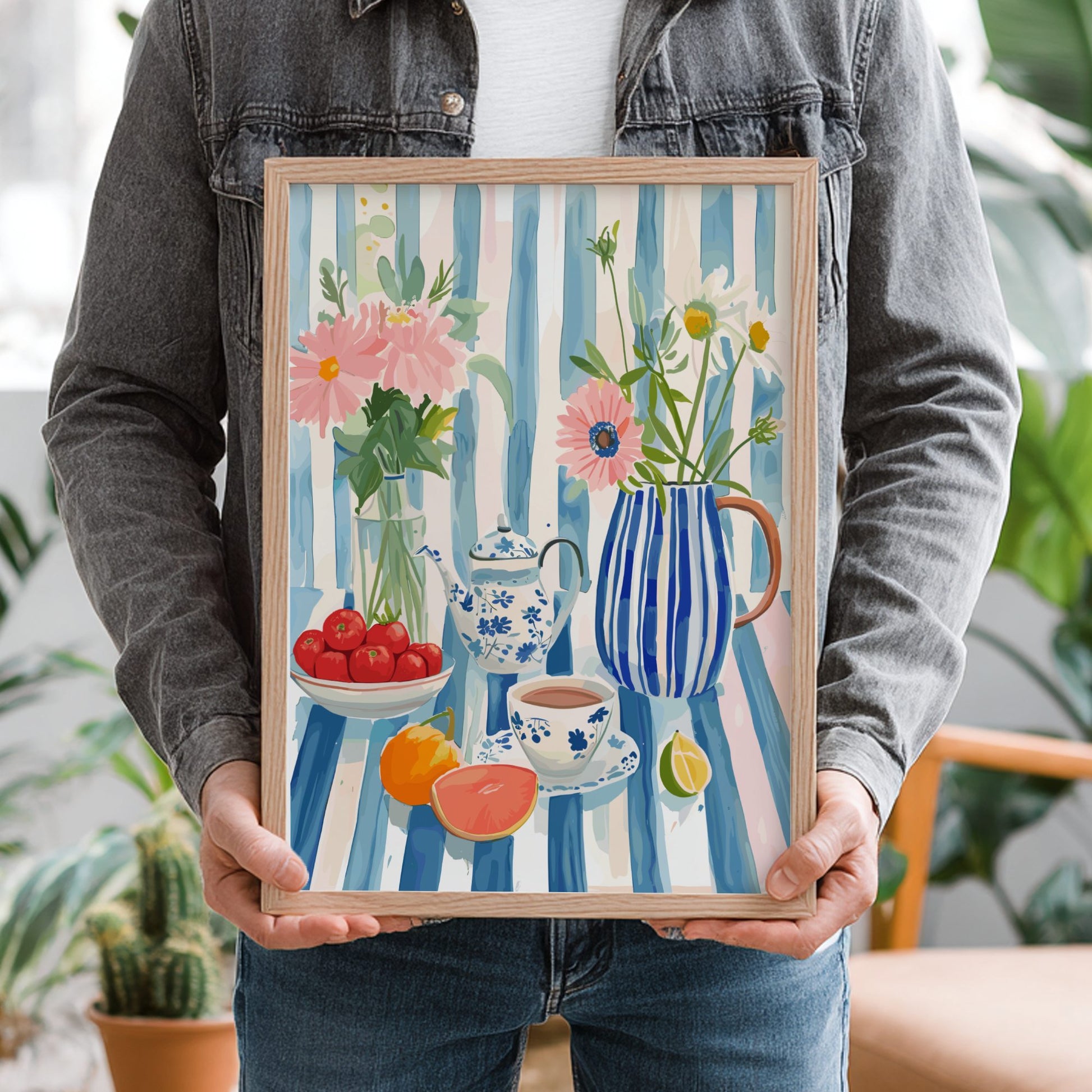 Person holding a framed painting with floral and still life elements.