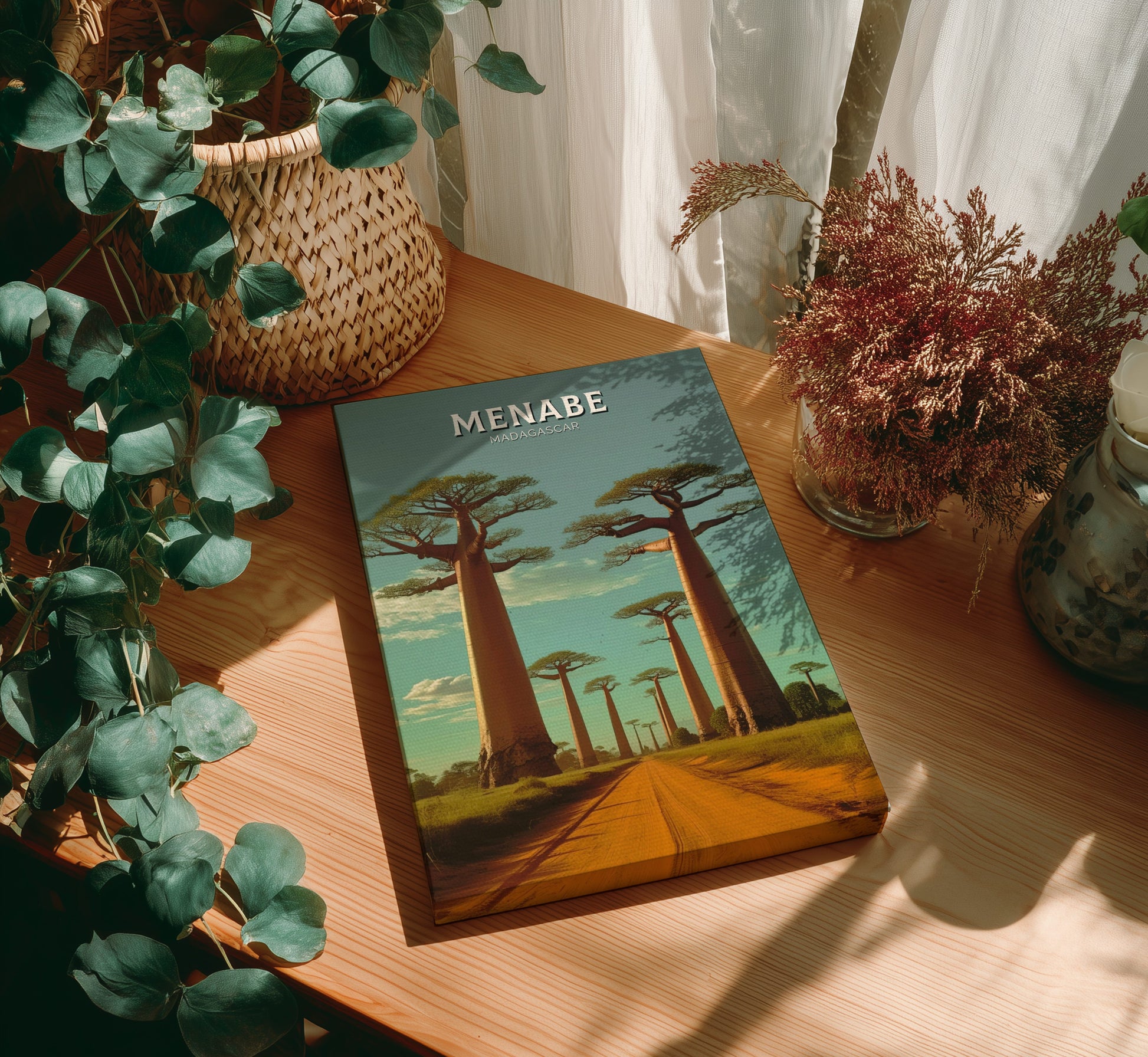 Book titled 'Menabe' on a wooden table with plants around