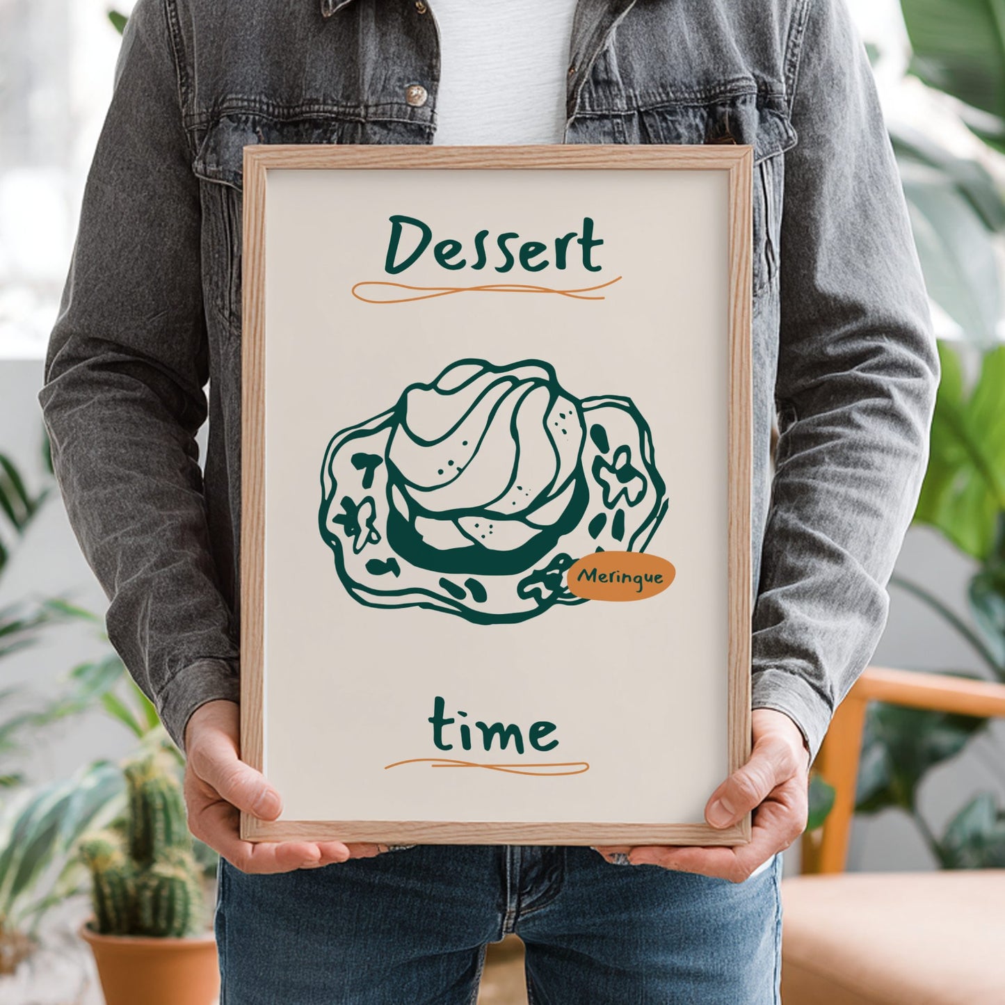 Person holding a framed print with a dessert illustration and text.