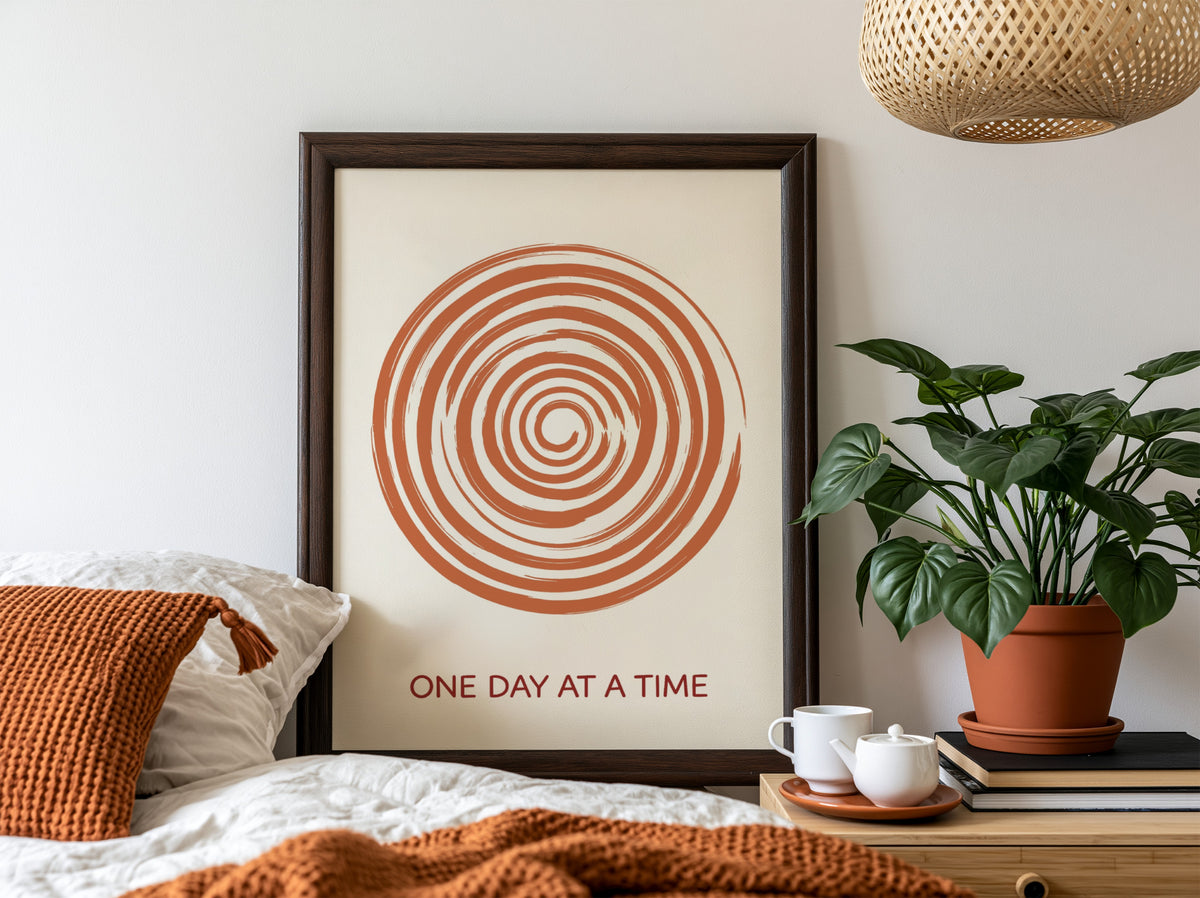 Motivational poster showing a burnt orange hand drawn spiral with One Day At A Time.
