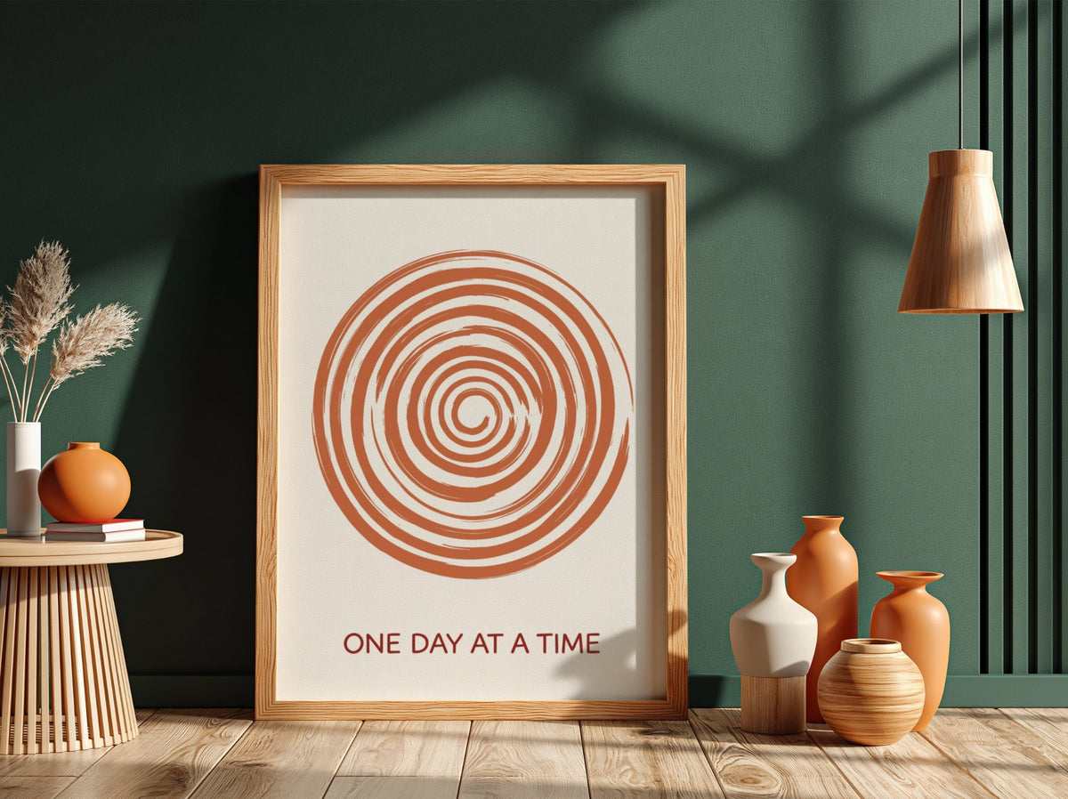 Motivational poster showing a burnt orange hand drawn spiral with One Day At A Time.