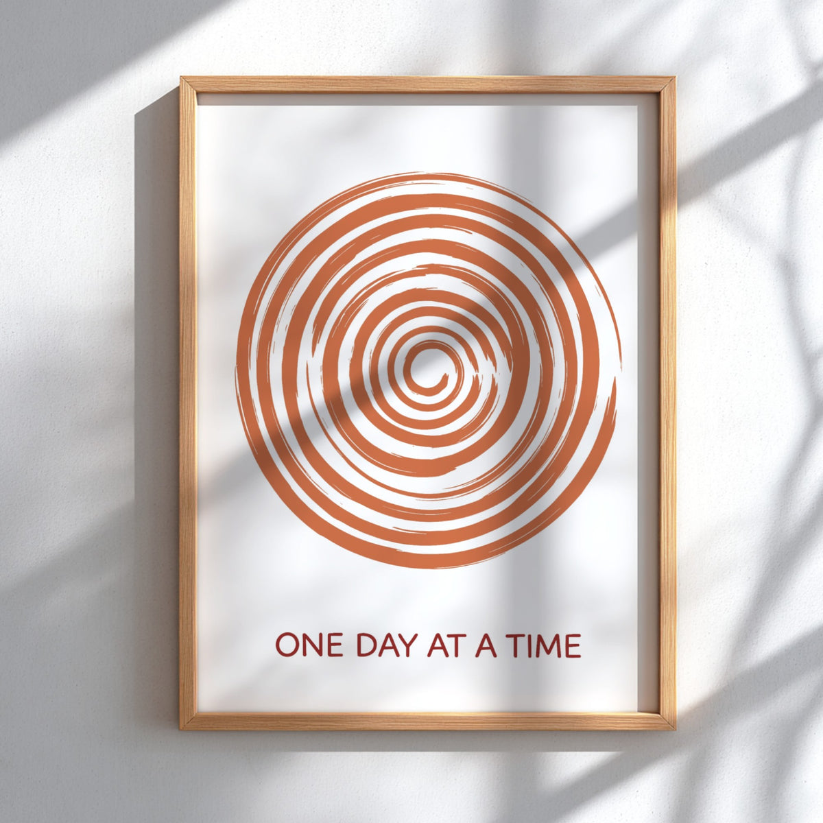 Motivational poster showing a burnt orange hand drawn spiral with One Day At A Time.