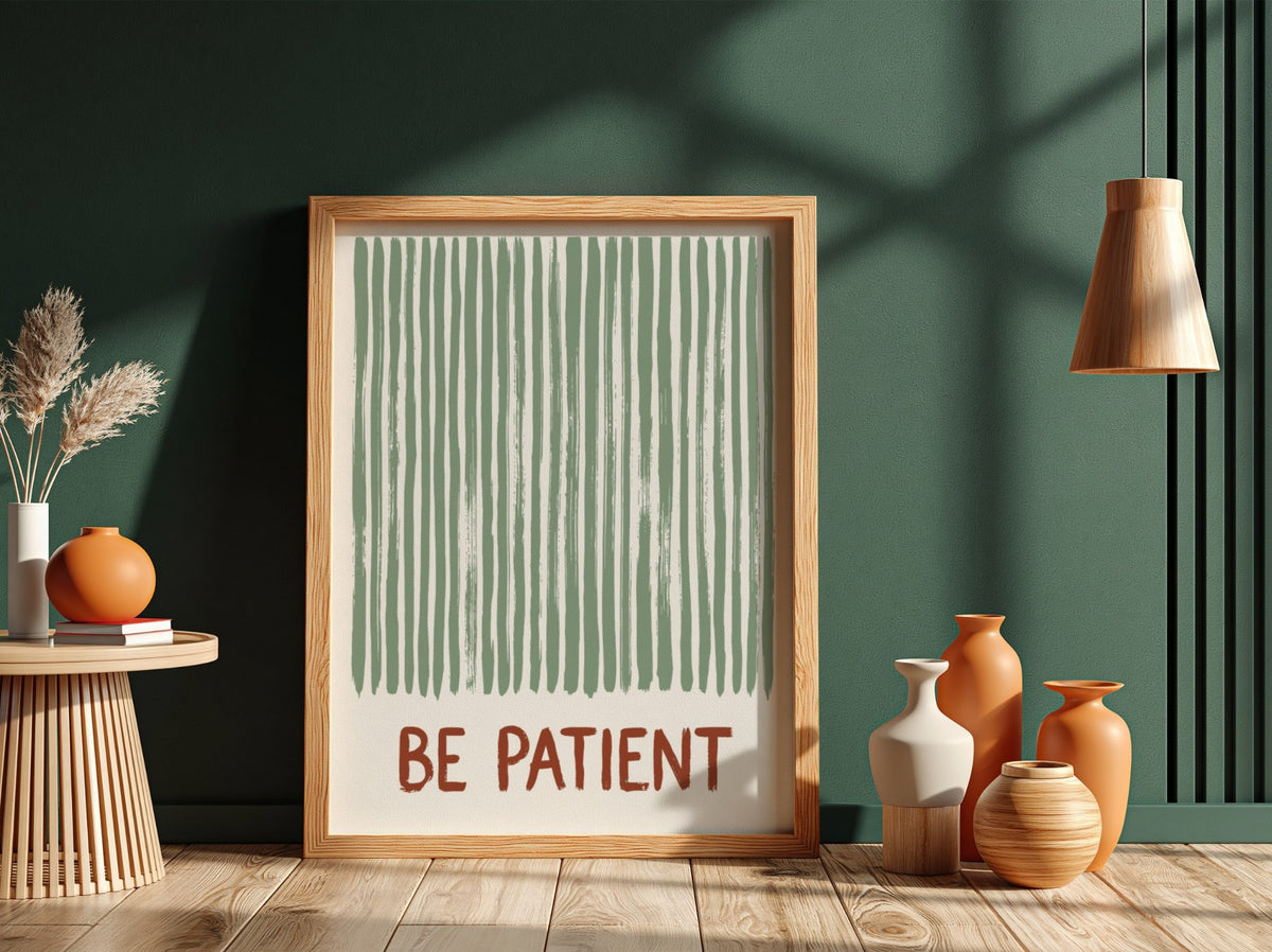 Motivational poster with sage green vertical brushstrokes and the text Be Patient in terracotta.