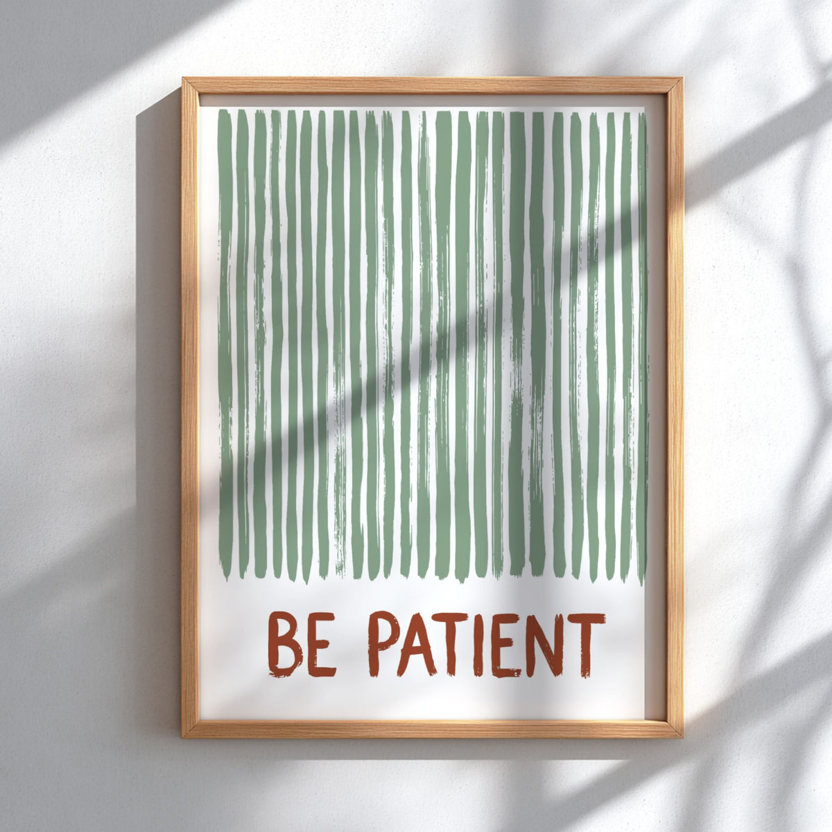 Motivational poster with sage green vertical brushstrokes and the text Be Patient in terracotta.