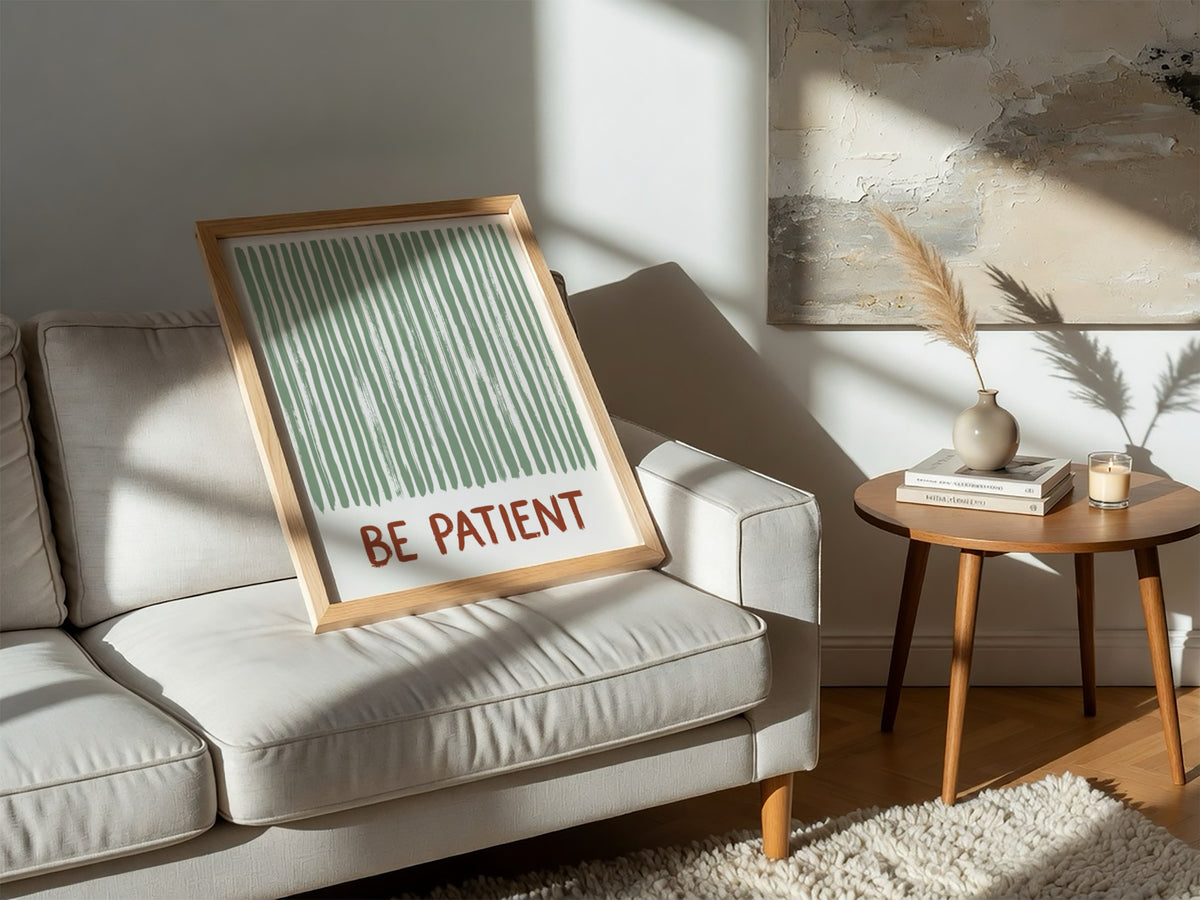Motivational poster with sage green vertical brushstrokes and the text Be Patient in terracotta.