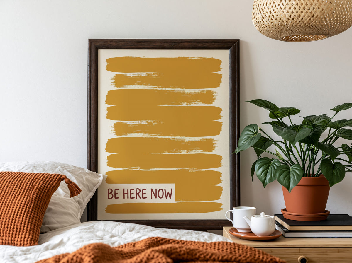 Motivational poster with yellow brushstrokes and the text Be Here Now in brown