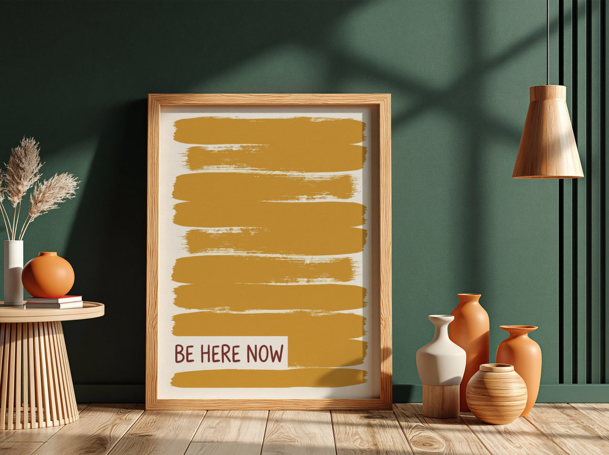 Motivational poster with yellow brushstrokes and the text Be Here Now in brown