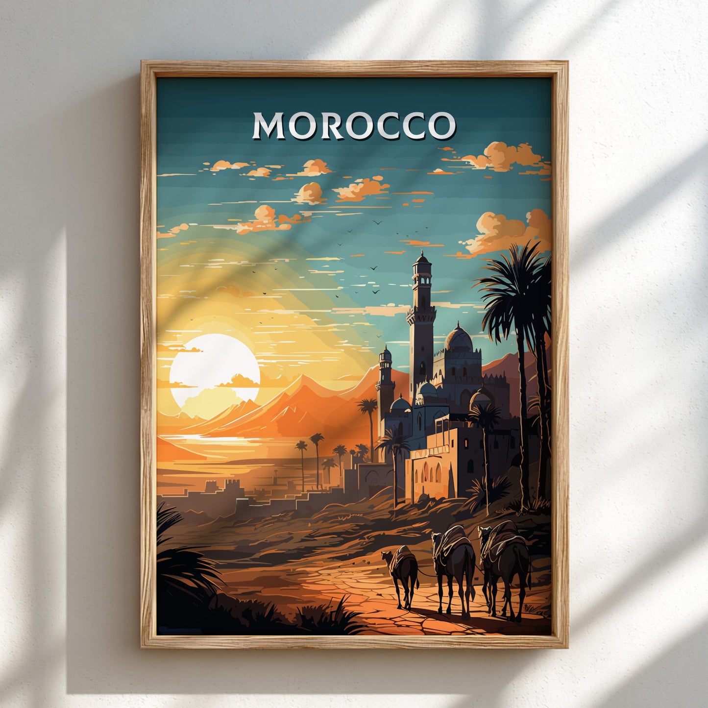 Framed artwork of a Moroccan landscape with sunset, palm trees, and buildings.