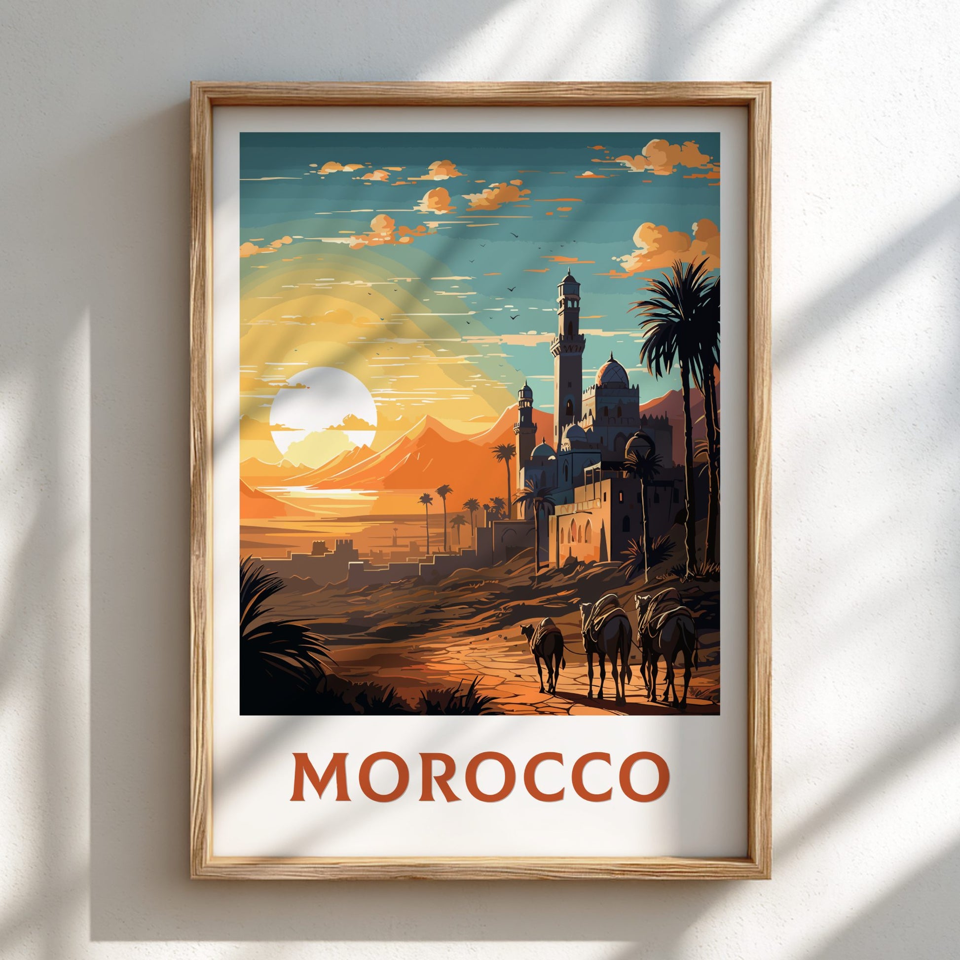 Framed artwork of a Moroccan landscape with a sunset, palm trees, and buildings.
