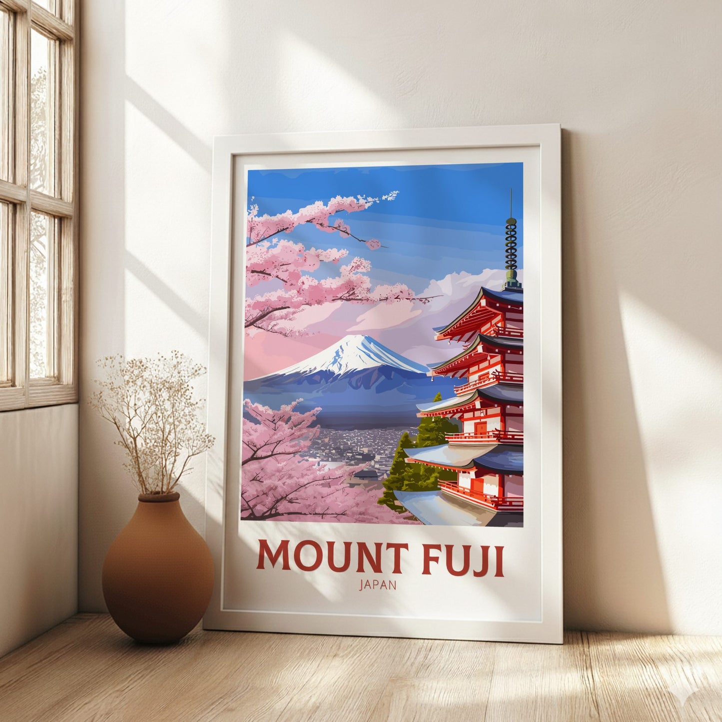 Framed poster of Mount Fuji and cherry blossoms in a room with a vase.