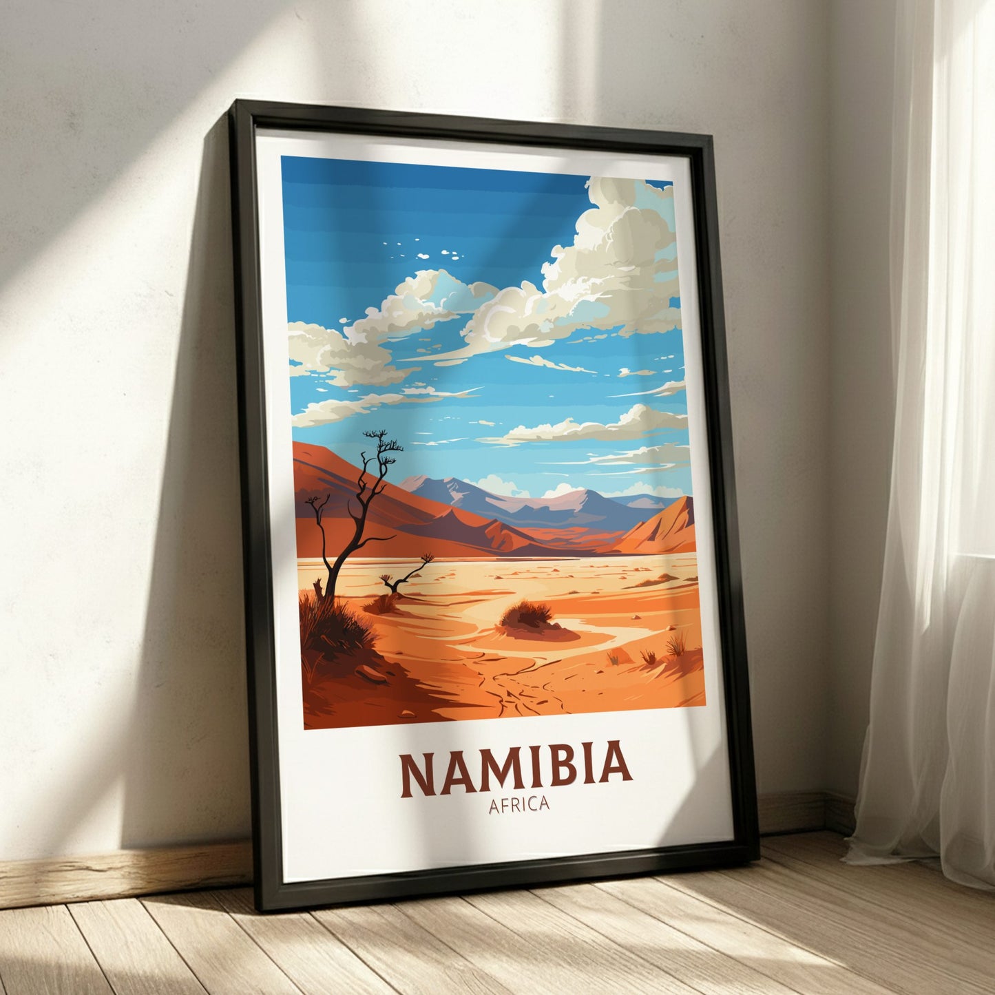 Framed poster of a desert landscape with mountains and the word 'Namibia' on a white wall.