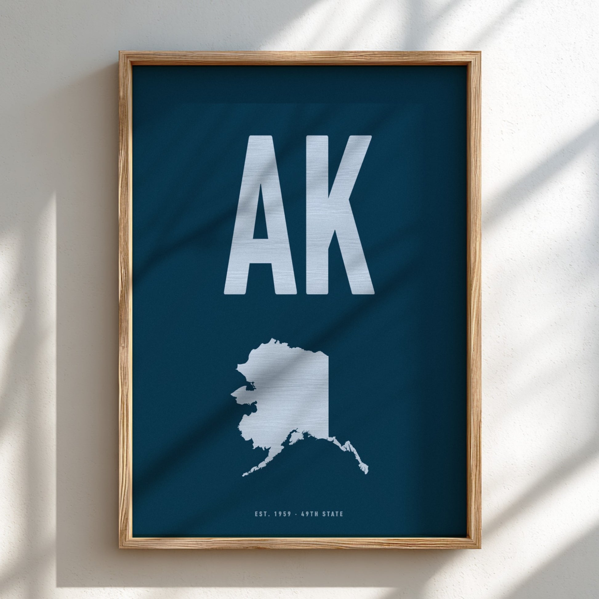 Framed poster with 'AK' and an outline of Alaska on a blue background