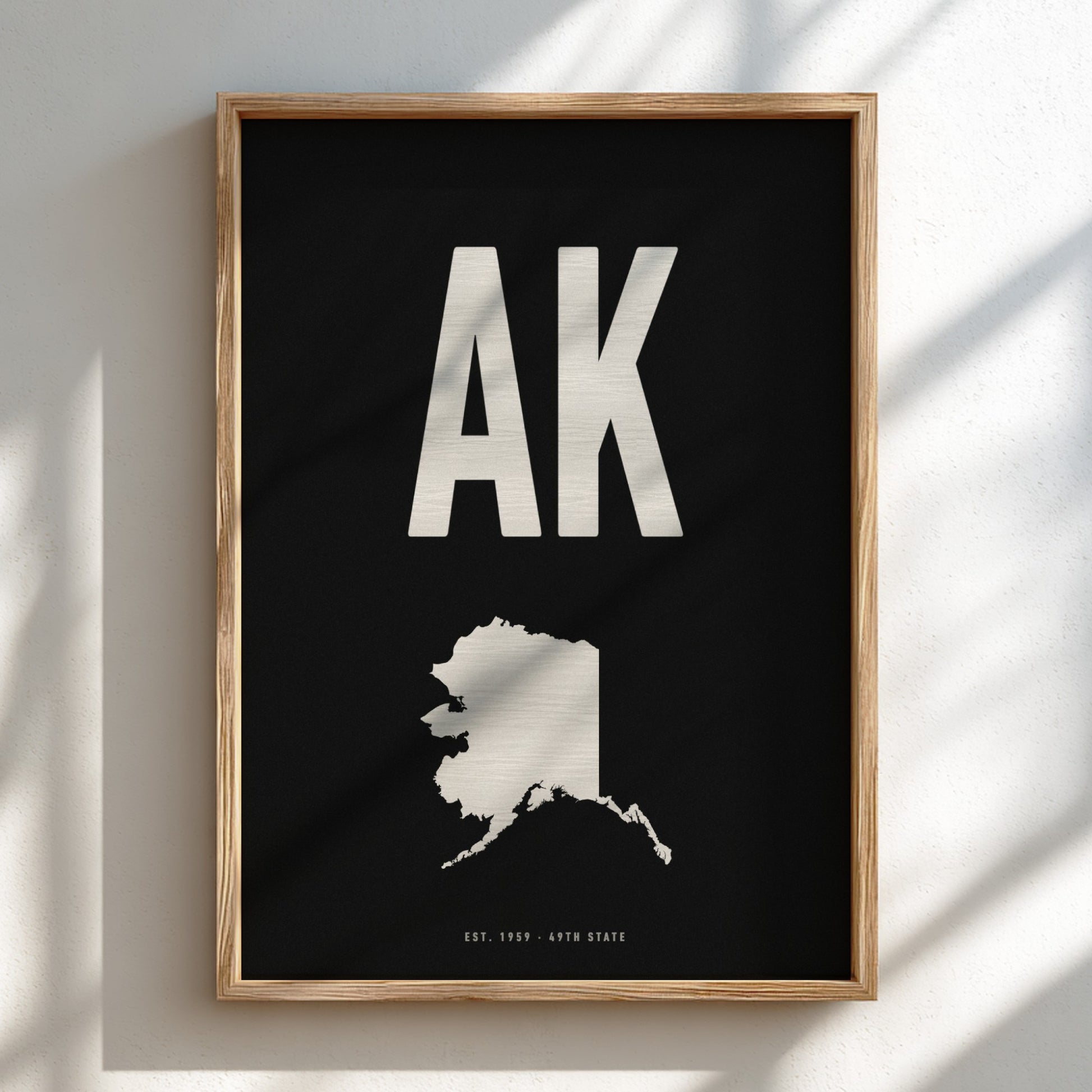 Framed poster with 'AK' and outline of Alaska on a black background