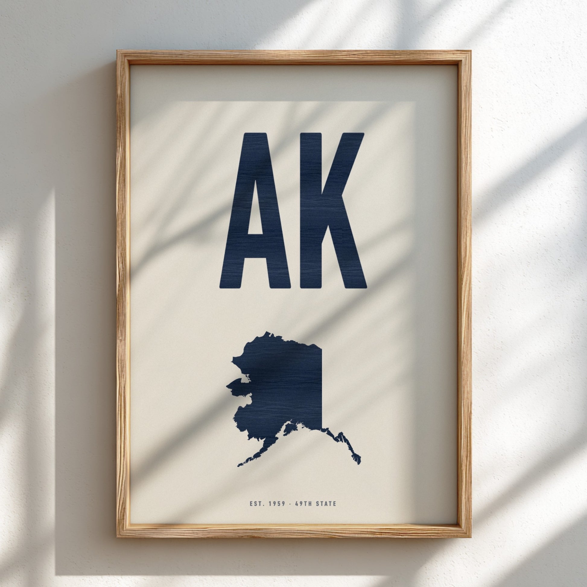 Framed artwork with 'AK' and a map of Alaska on a light background