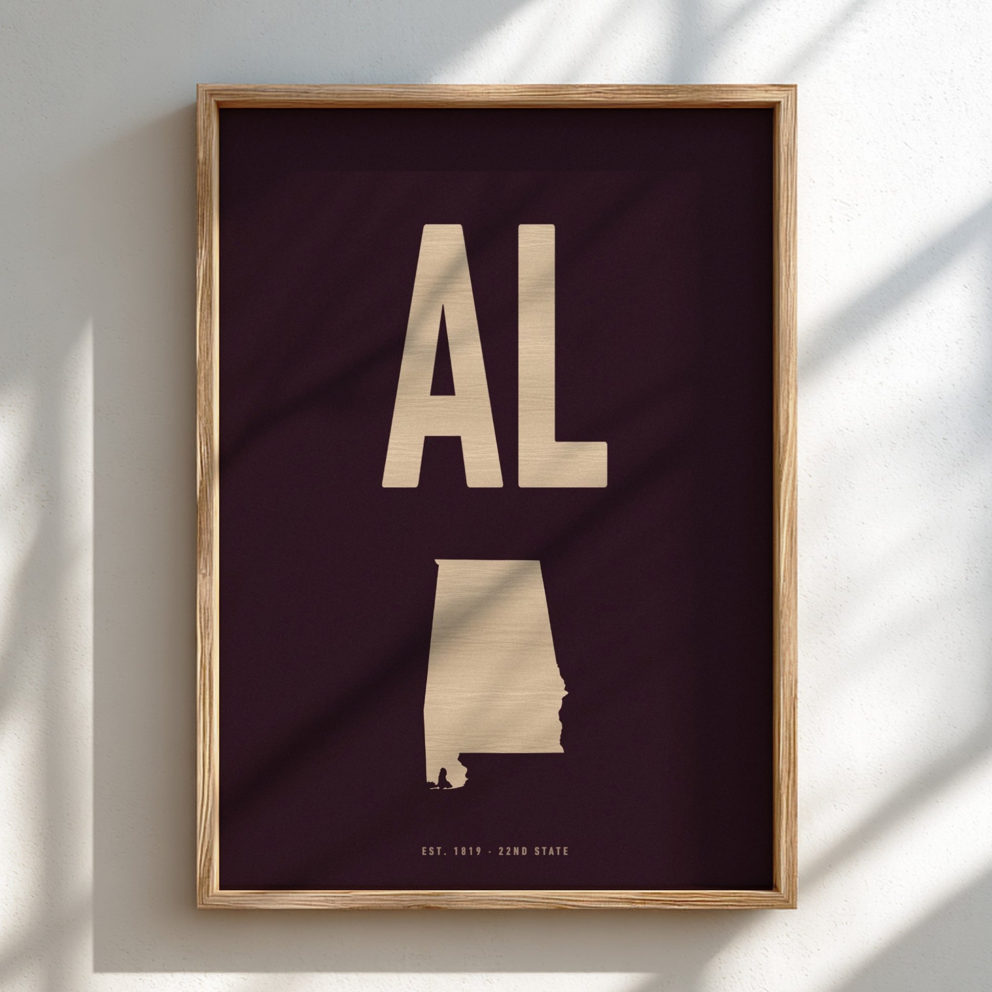 Framed artwork with 'AL' and a map of Alabama on a dark background