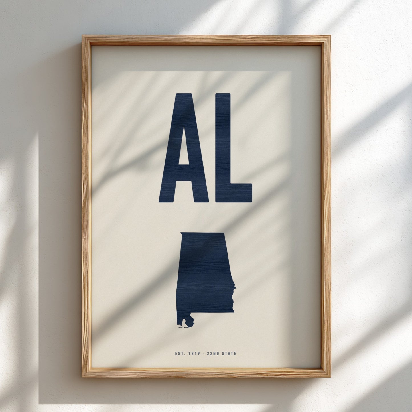 Framed artwork of the state of Alabama with 'AL' on a light background
