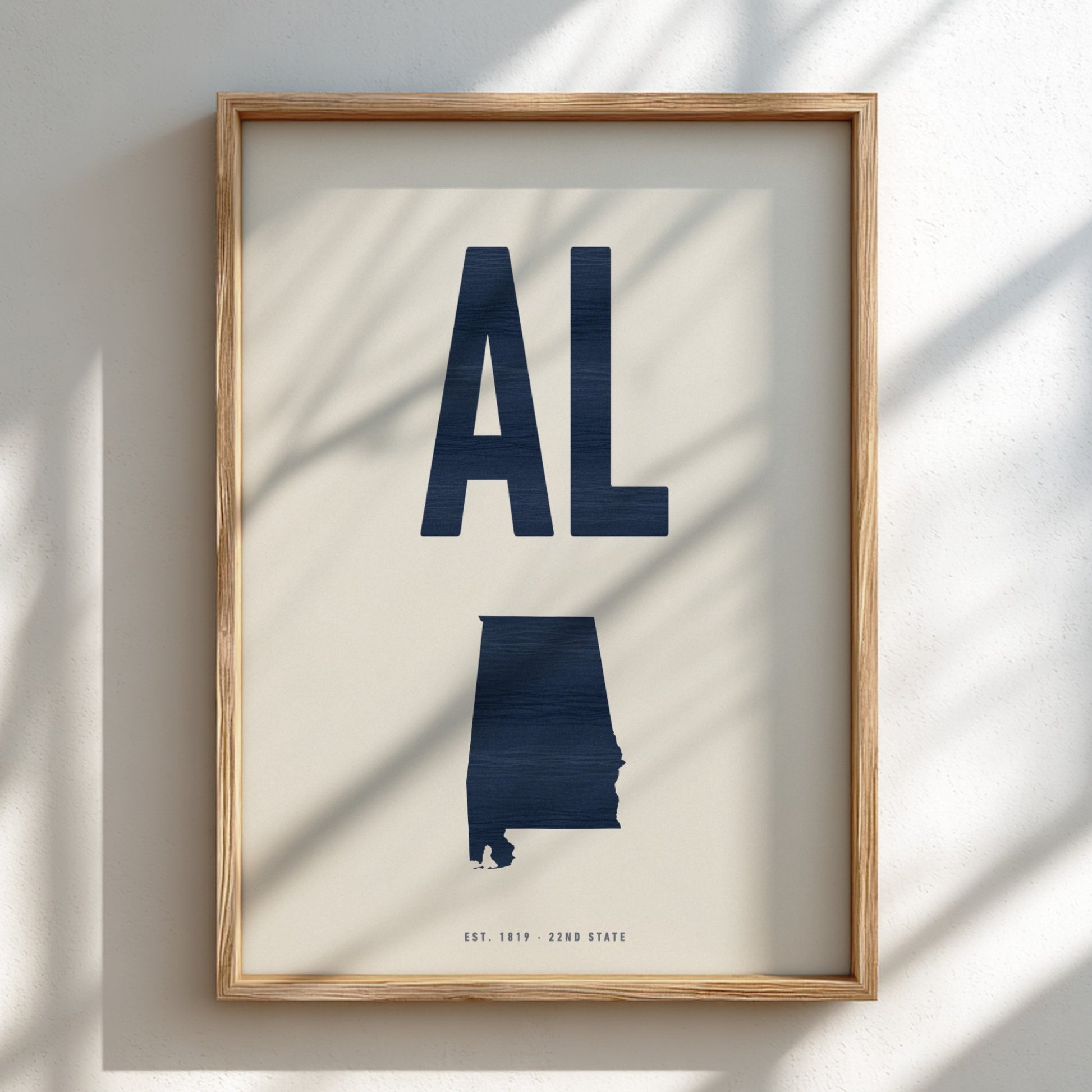 Framed artwork of the state of Alabama with 'AL' on a light background