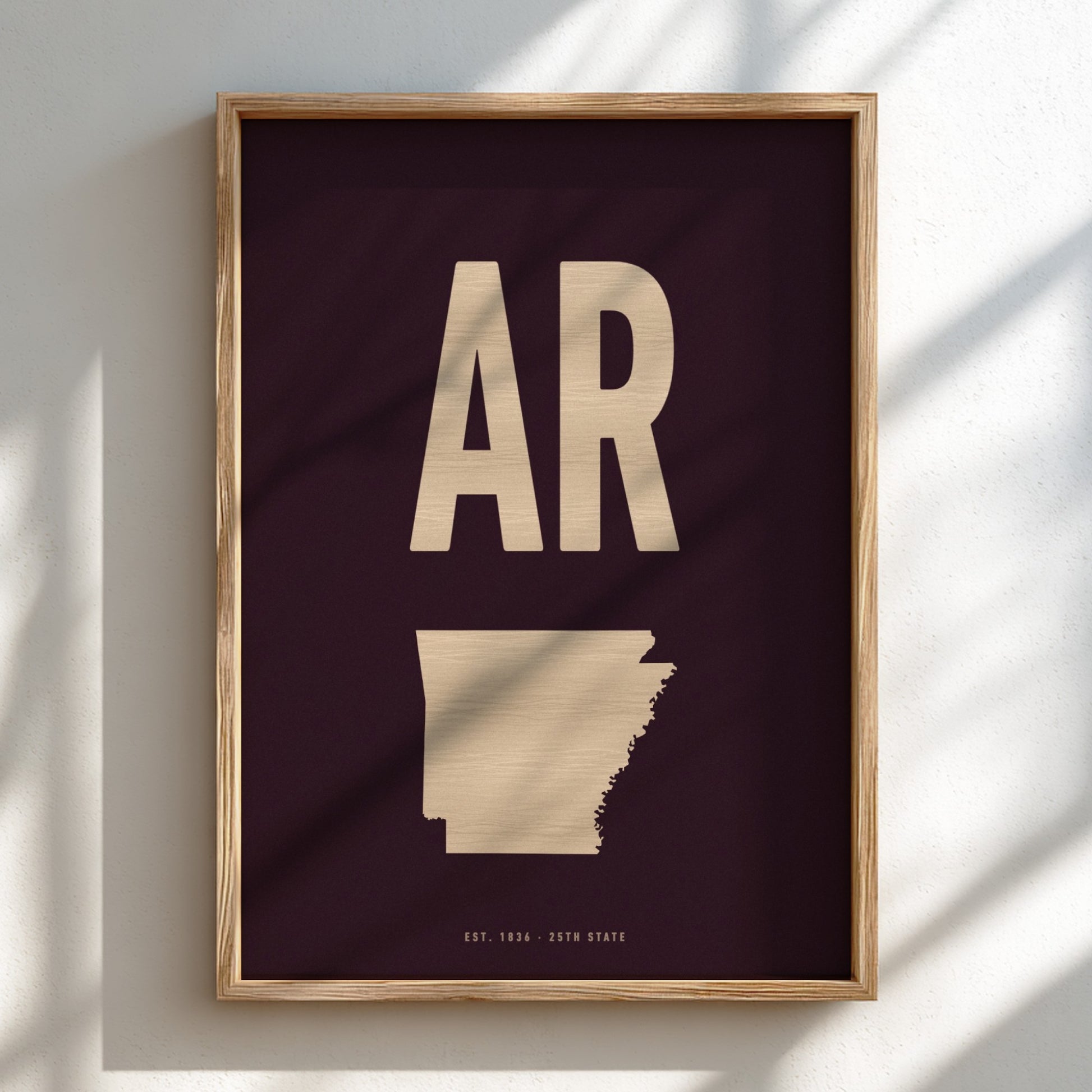 Framed artwork with 'AR' and a map of Arkansas on a dark background