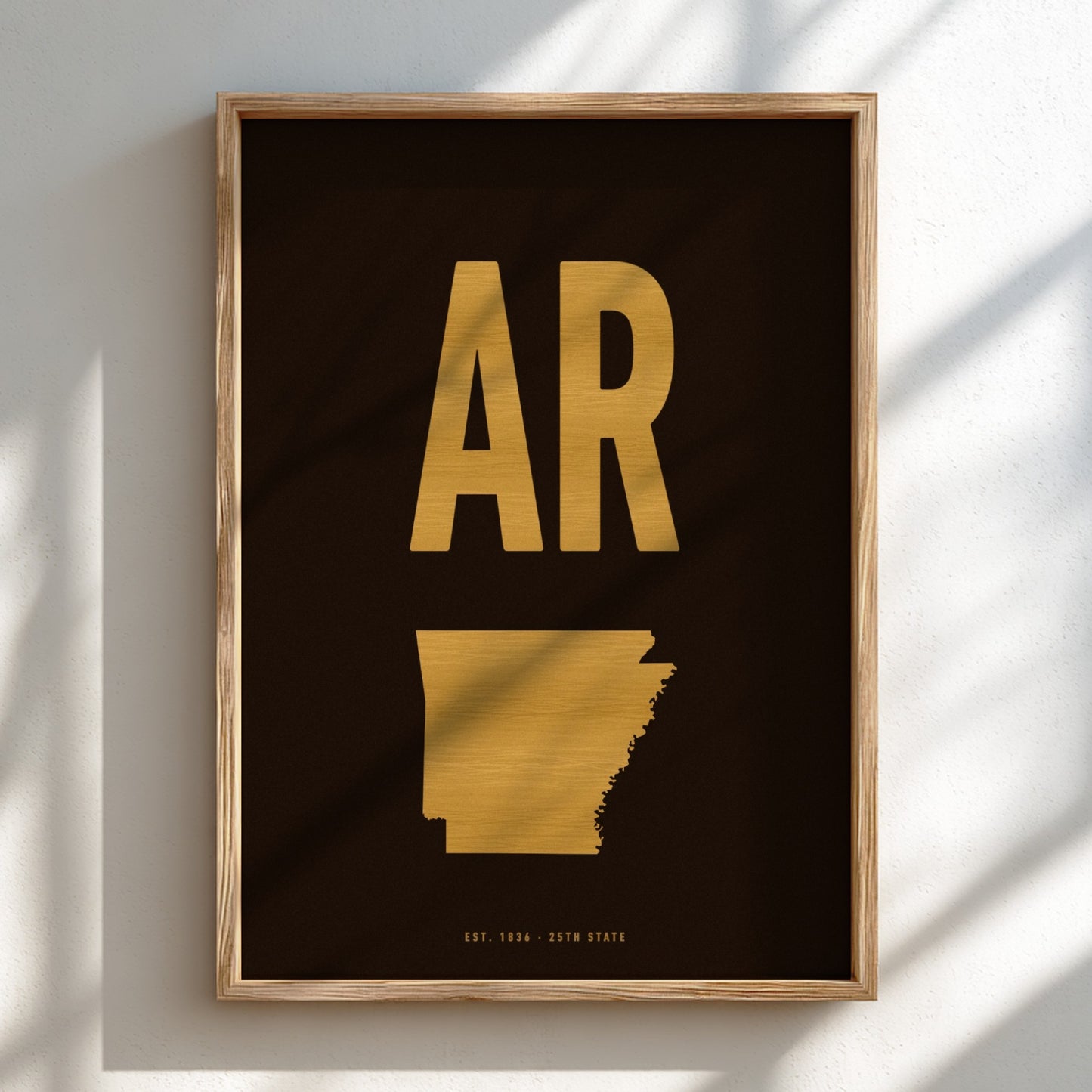 Framed artwork with gold 'AR' and state outline on black background