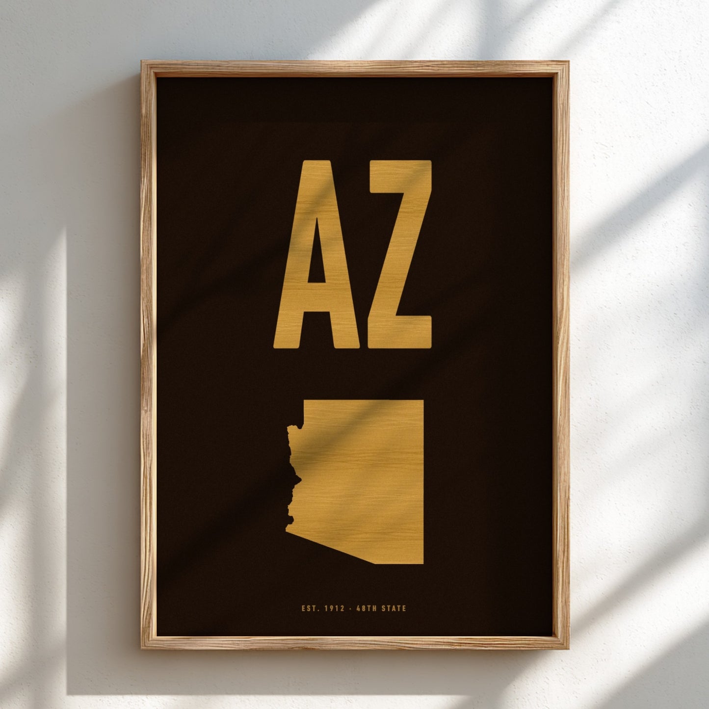 Framed artwork with gold 'AZ' and state outline on a black background