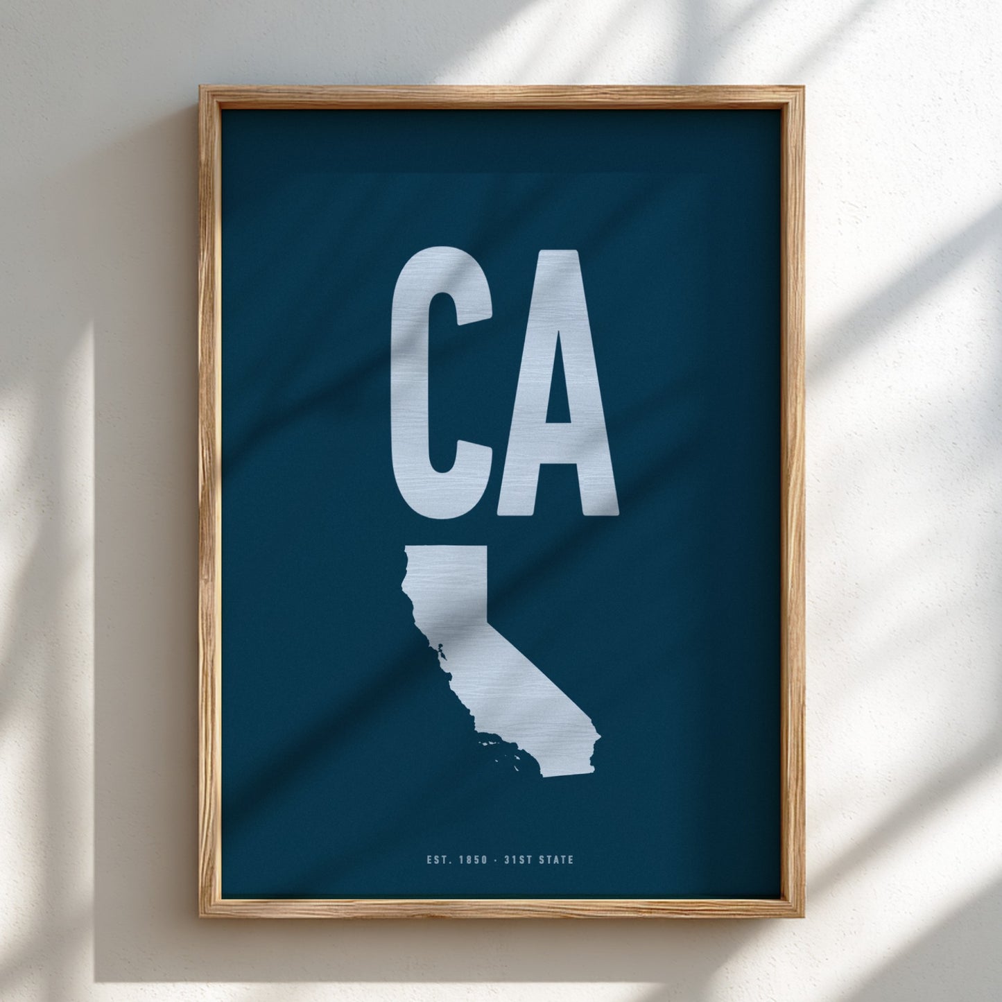 Framed artwork of a white 'CA' on a blue background, likely representing California.