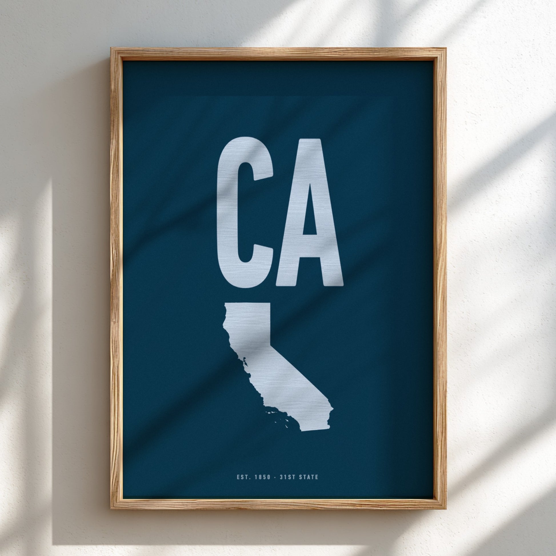 Framed artwork of a white 'CA' on a blue background, likely representing California.