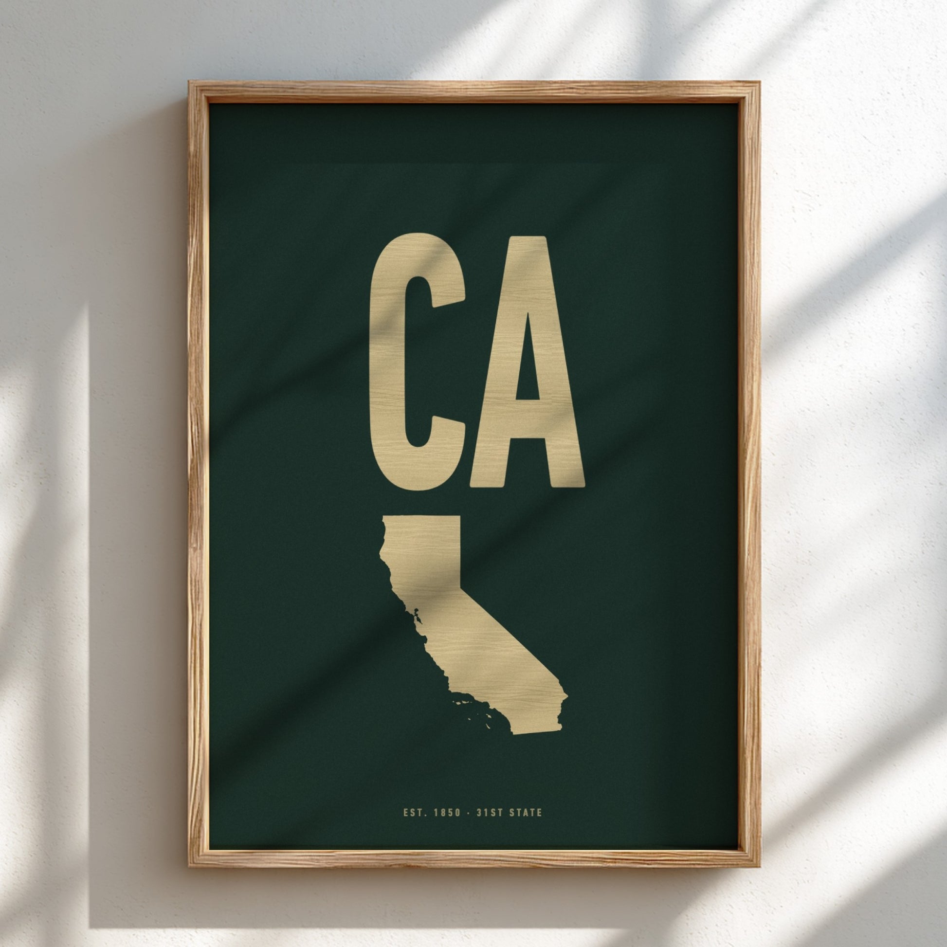 Framed artwork of a gold 'CA' on a dark green background