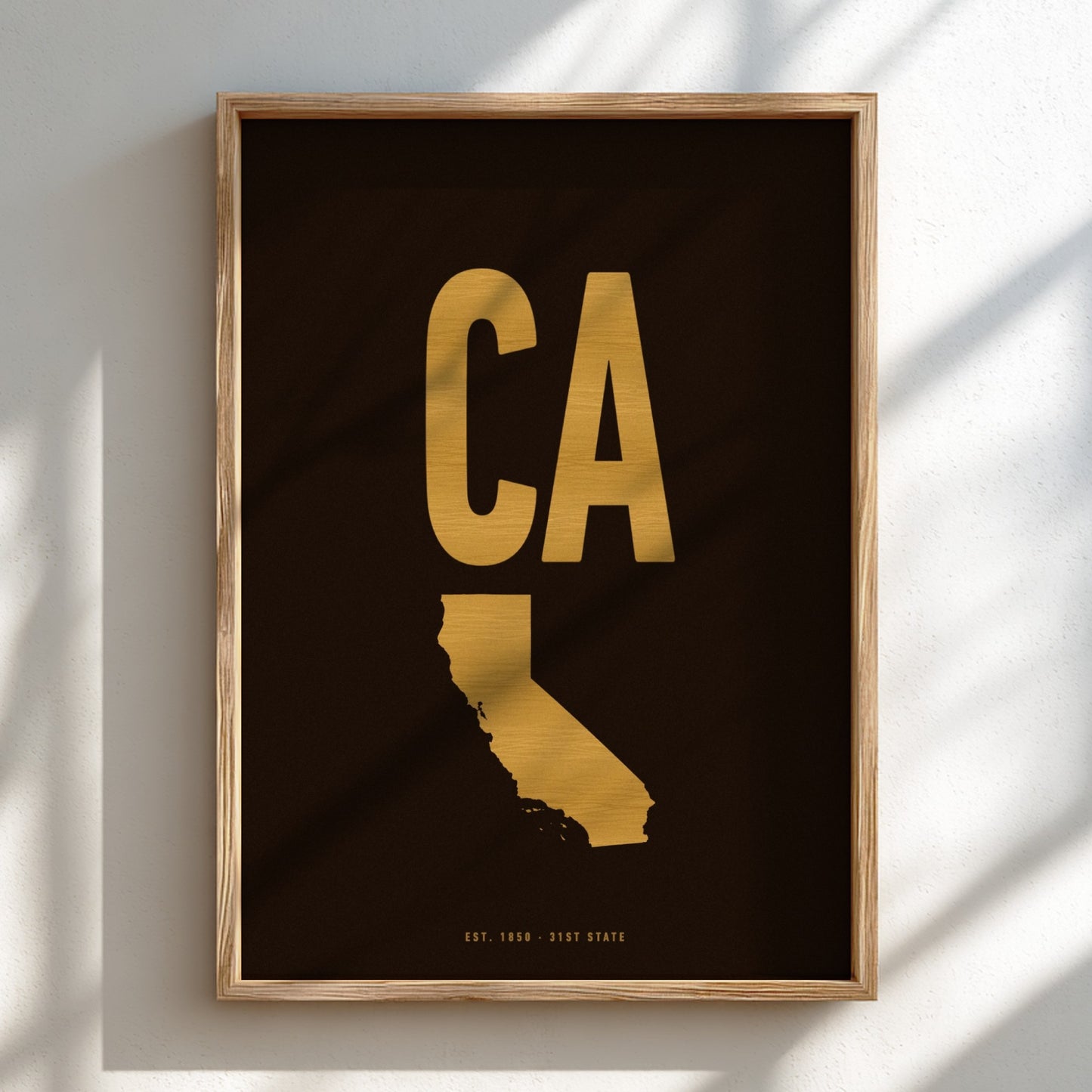 Framed artwork with gold 'CA' and state outline on black background