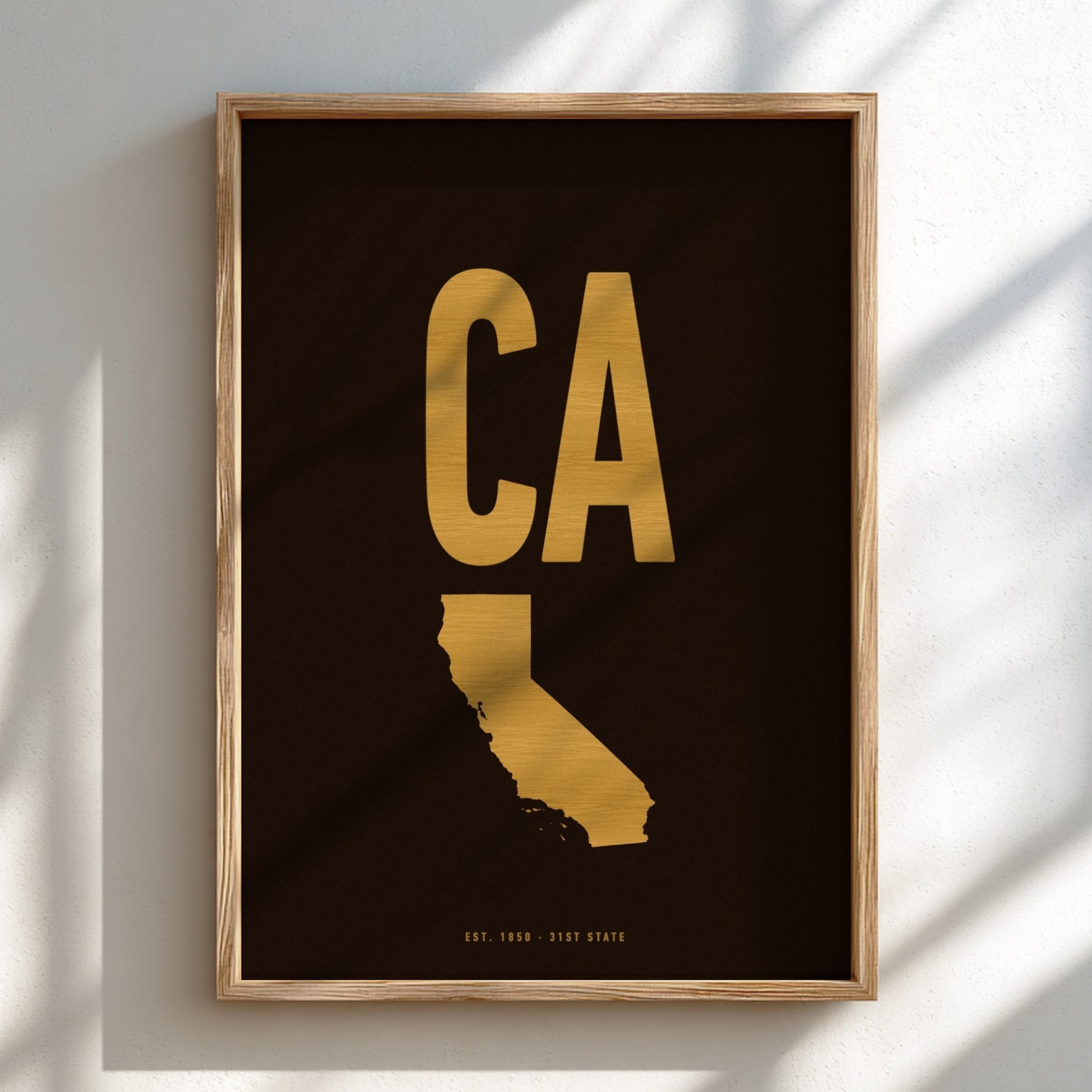 Framed artwork with gold 'CA' and state outline on black background