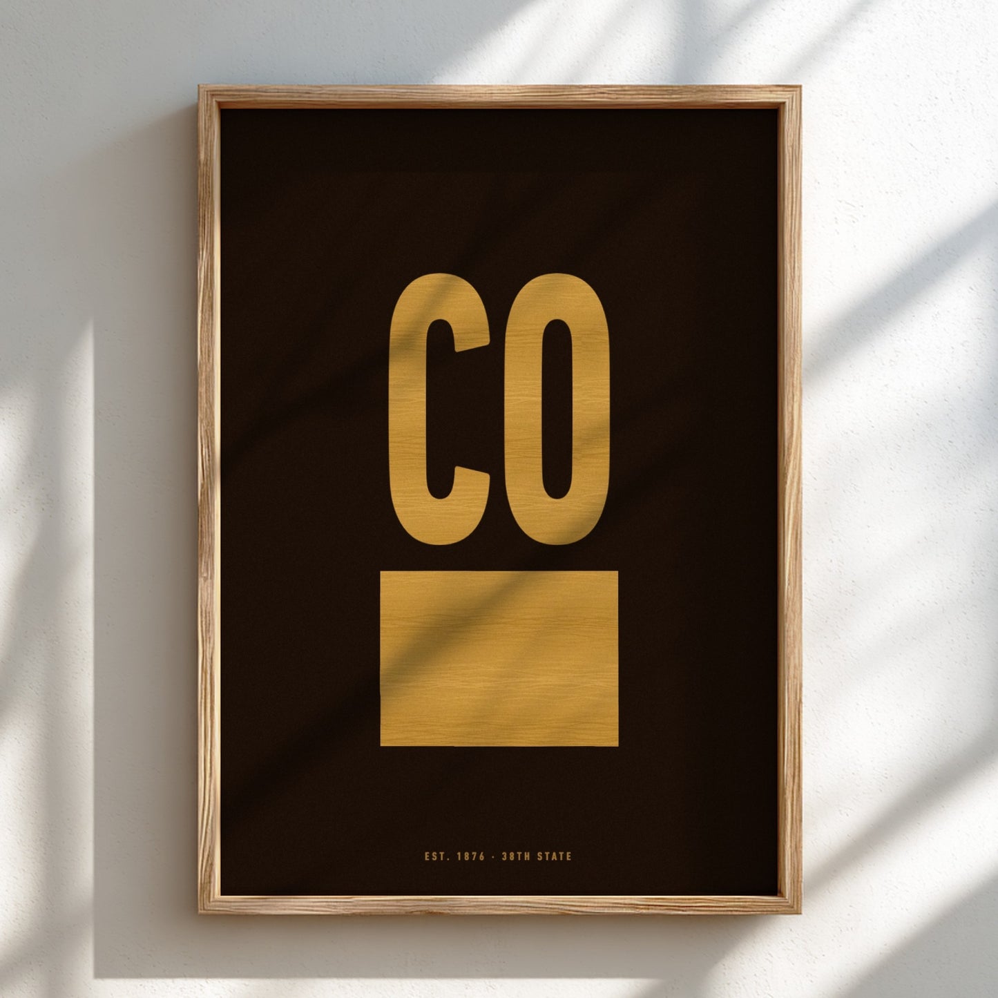 Framed artwork with 'CO' in gold on a black background