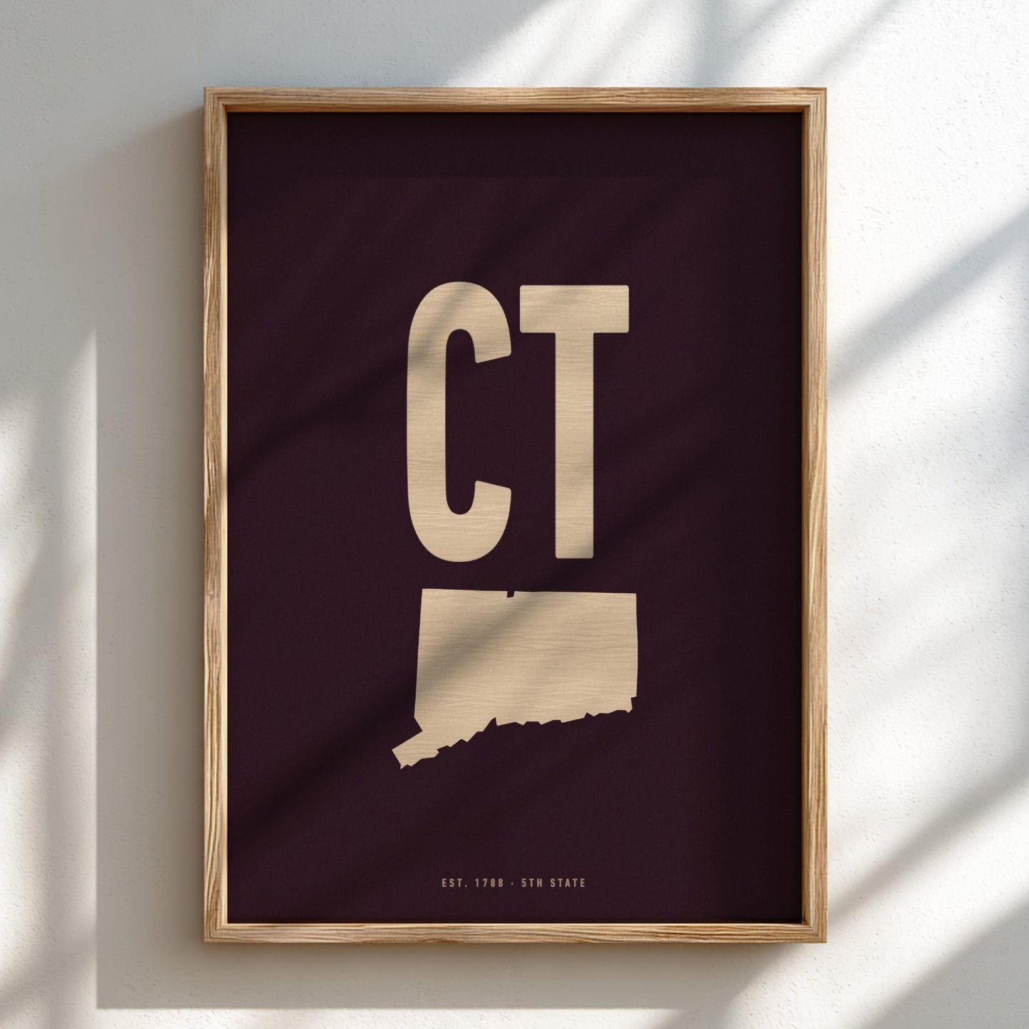 Framed artwork with 'CT' and a map of Connecticut on a dark background