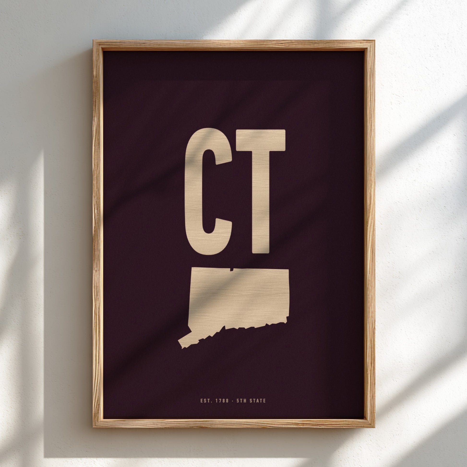 Framed artwork with 'CT' and a map of Connecticut on a dark background
