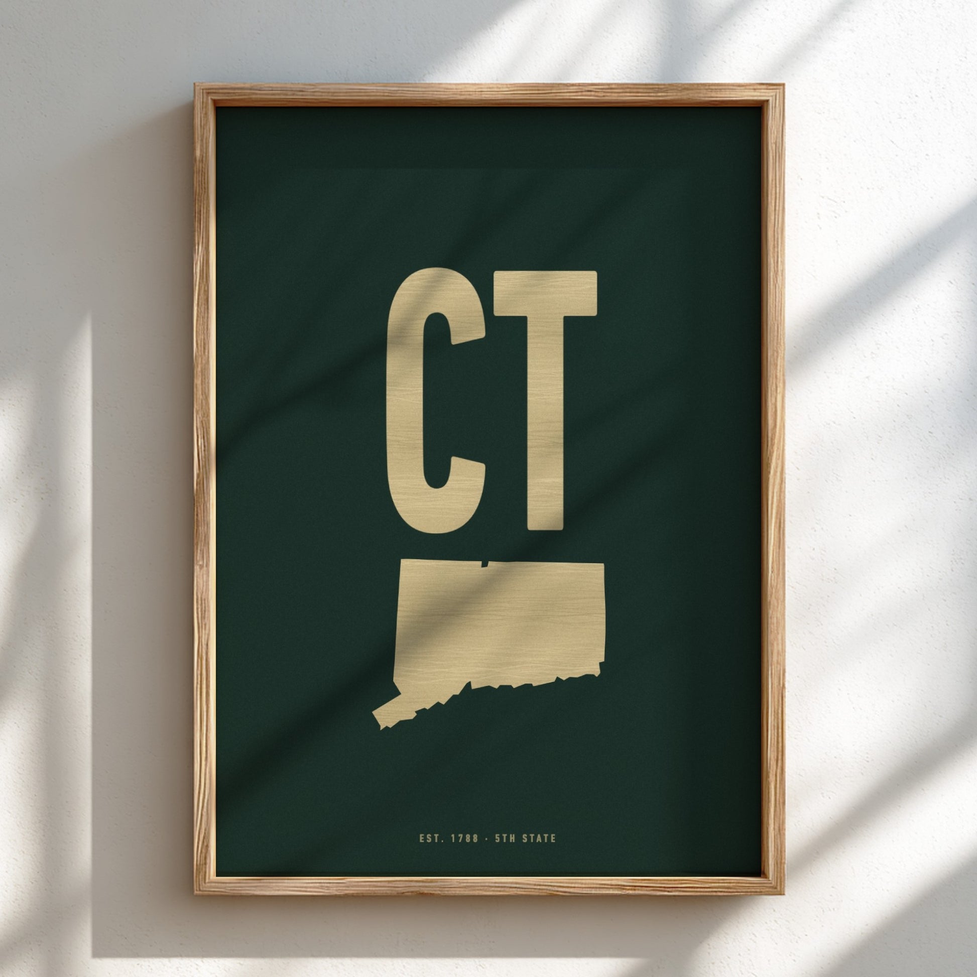 Framed artwork with 'CT' initials on a dark green background