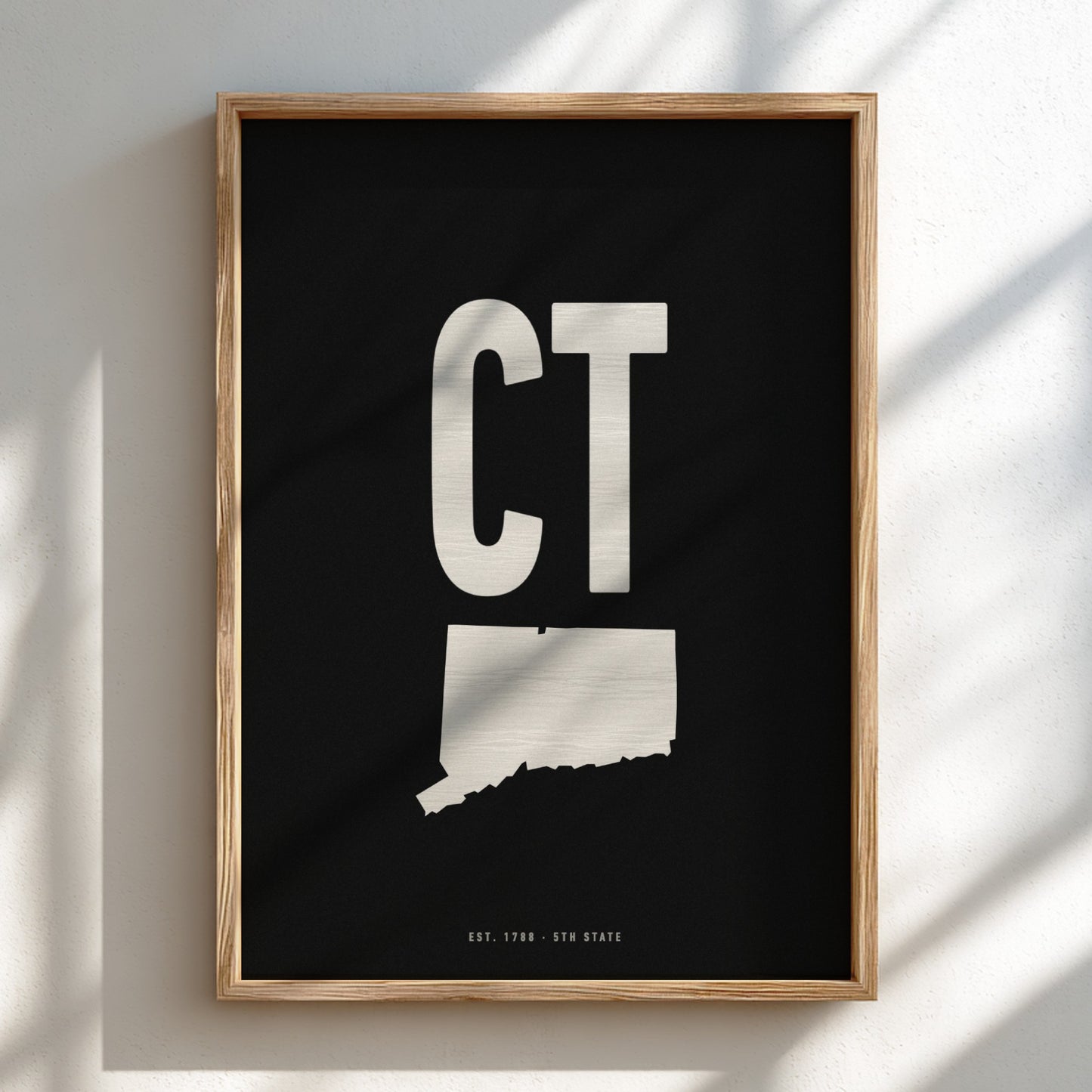 Framed artwork with 'CT' and a map of Connecticut on a black background