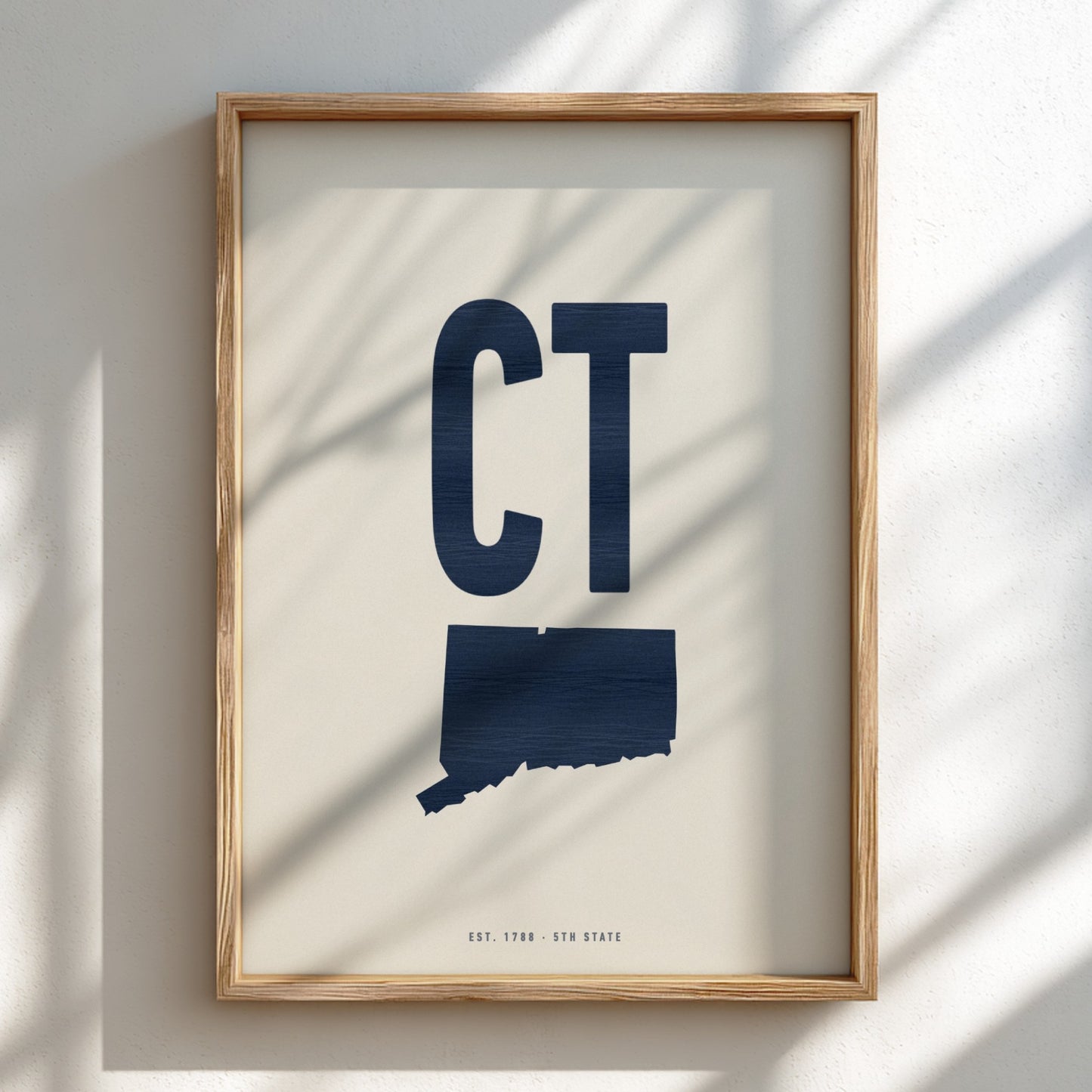 Framed artwork with 'CT' and a map of Connecticut on a light background