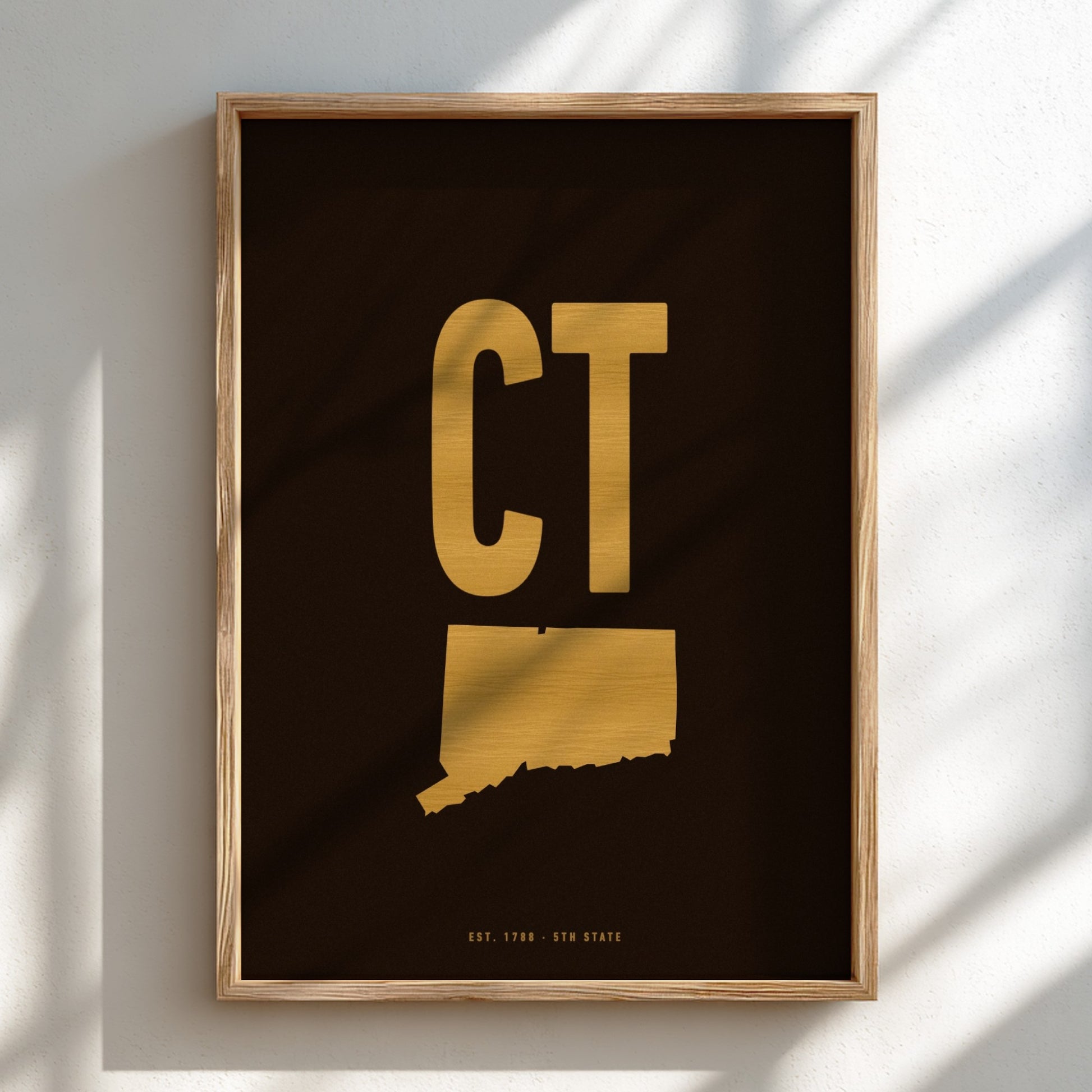 Framed artwork with gold 'CT' on a black background