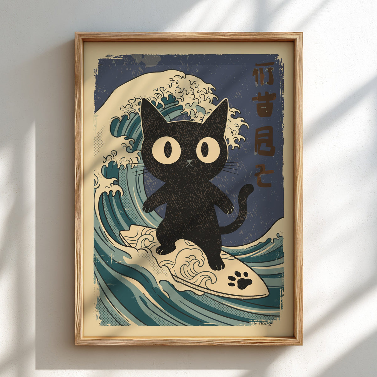 A framed art print featuring a black cat surfing on a wave in a retro Japanese style, mounted on a white wall with soft diagonal shadows.