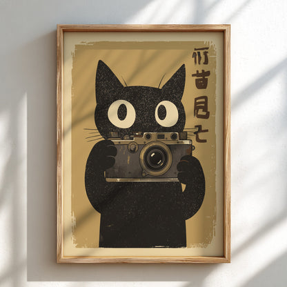 Framed wall art featuring a black cat illustration holding a vintage camera, with vertical Japanese characters on the right, displayed against a white wall with soft shadow patterns.