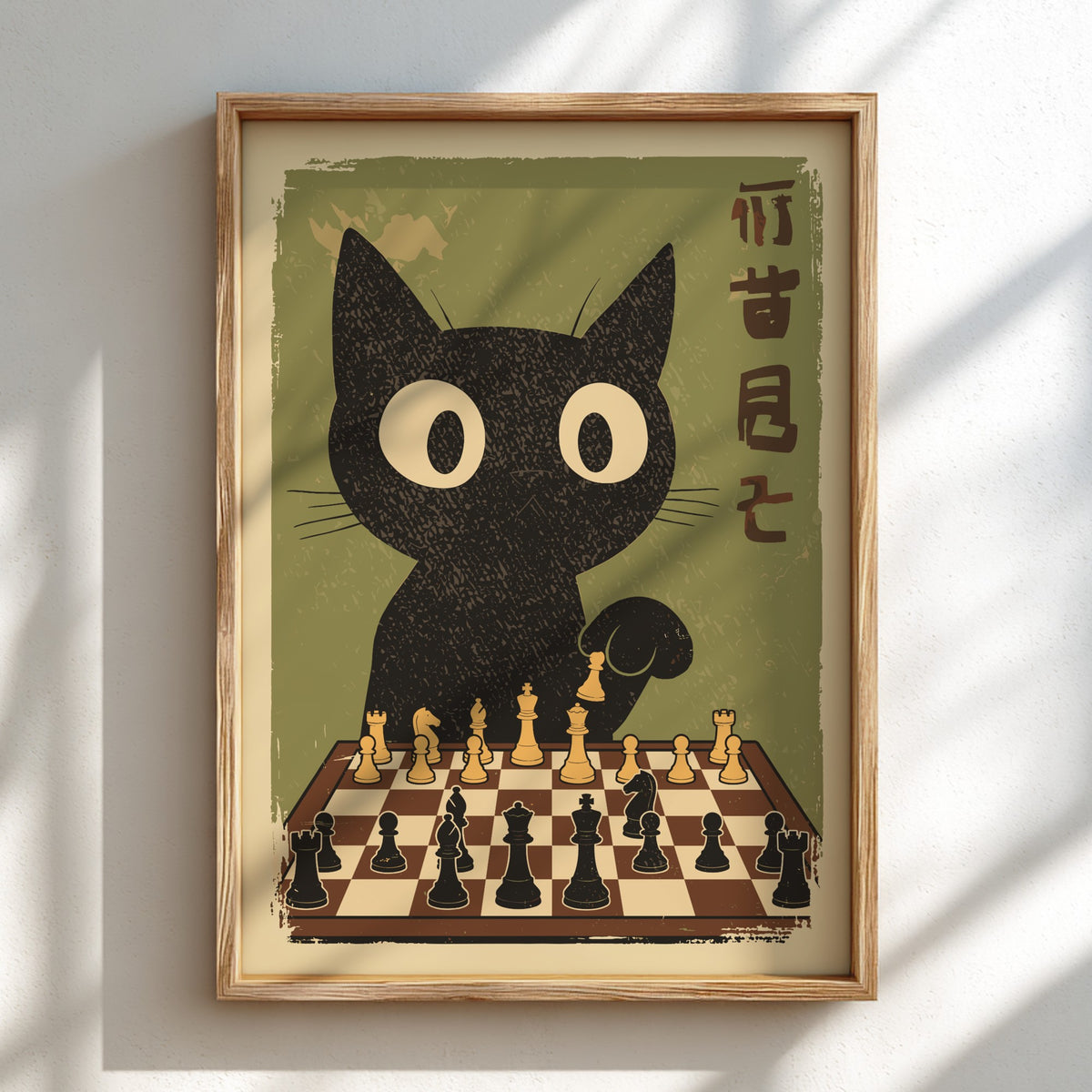 A framed art print featuring a stylized black cat with large white eyes contemplating a chess game on a chessboard, set against an olive green background with vertical Japanese characters. The print is housed in a light wood frame and mounted on a white wall with soft diagonal shadows.