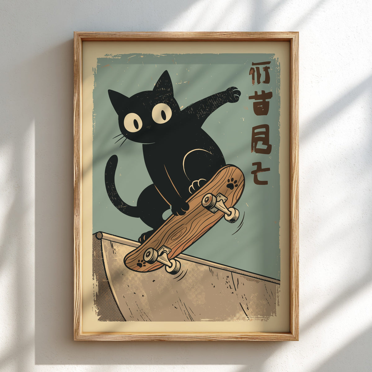 A framed art print featuring a black cat balancing on a skateboard on a ramp, with vertical Japanese characters on the right, displayed on a white wall with soft window shadows.