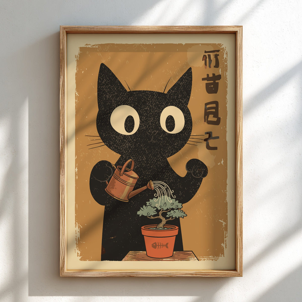 A framed art print featuring a black cat watering a small potted plant, displayed on a light wall with soft diagonal shadows.