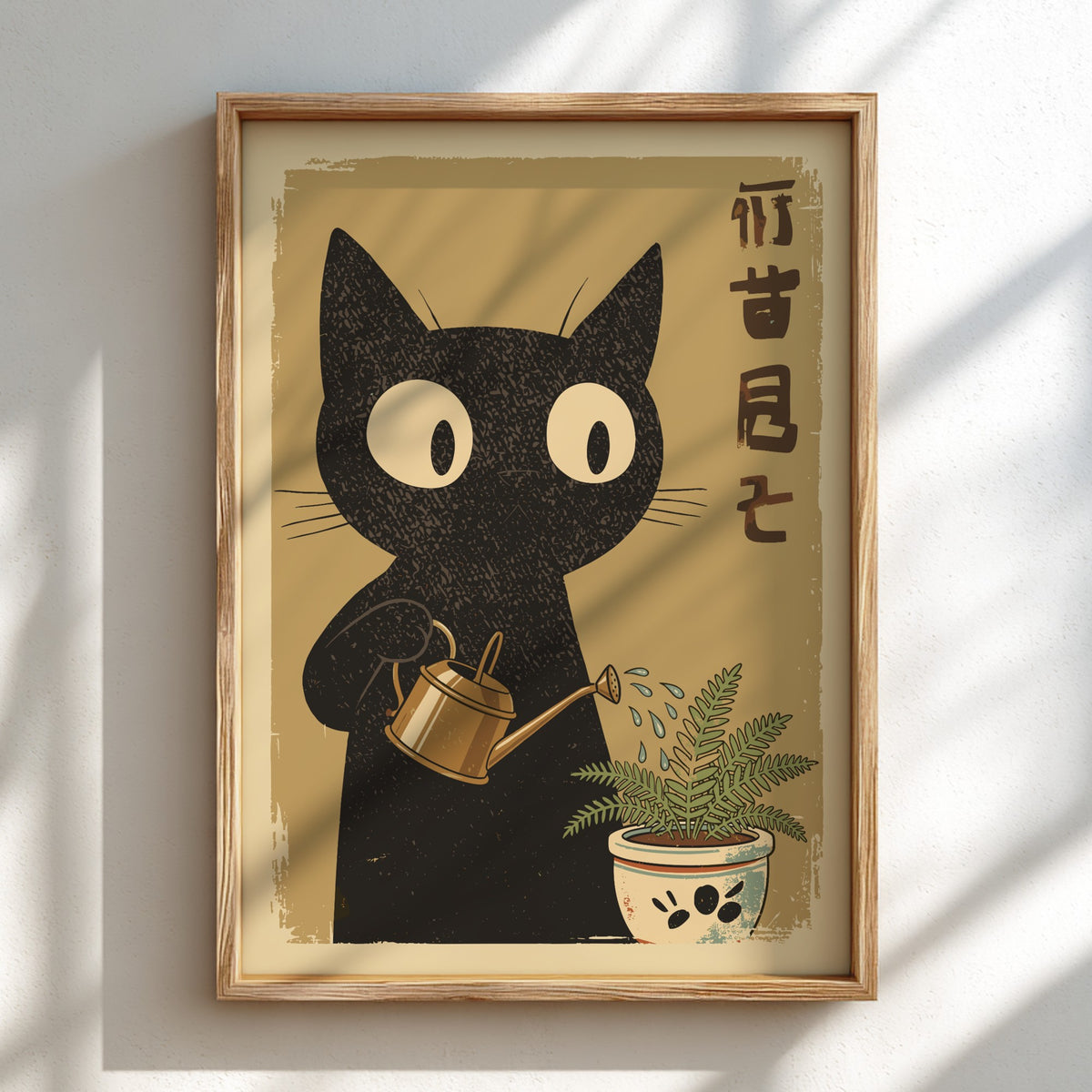 A framed art print featuring a black cat watering a small potted plant, displayed on a light wall with soft diagonal shadows.