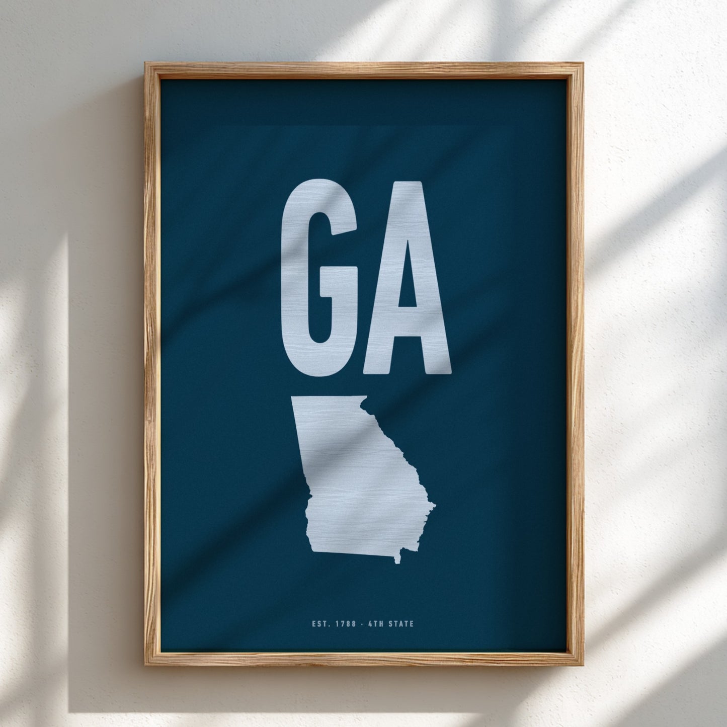 Framed poster with a map of Georgia and 'GA' on a blue background