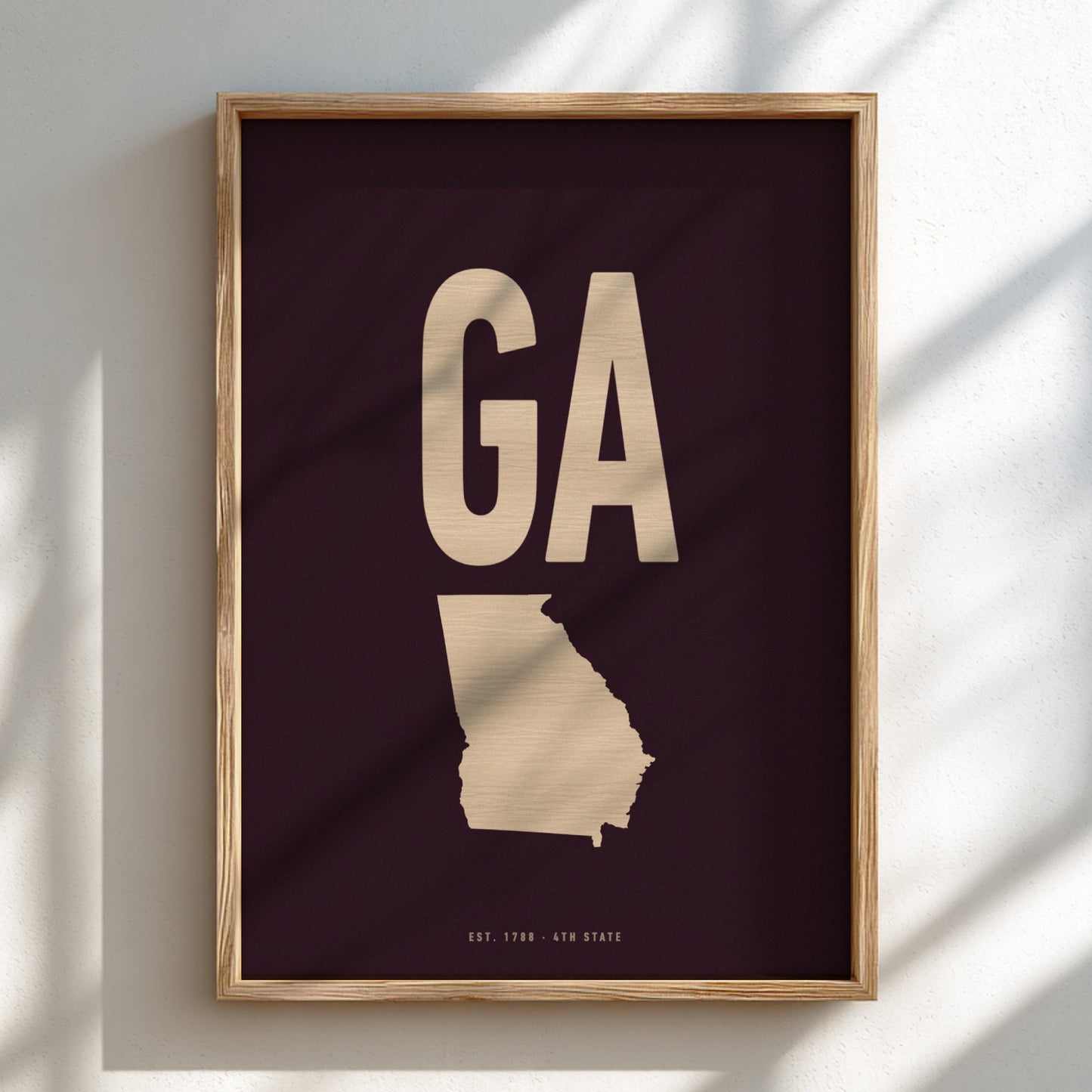 Framed artwork with 'GA' and a map of Georgia on a dark background