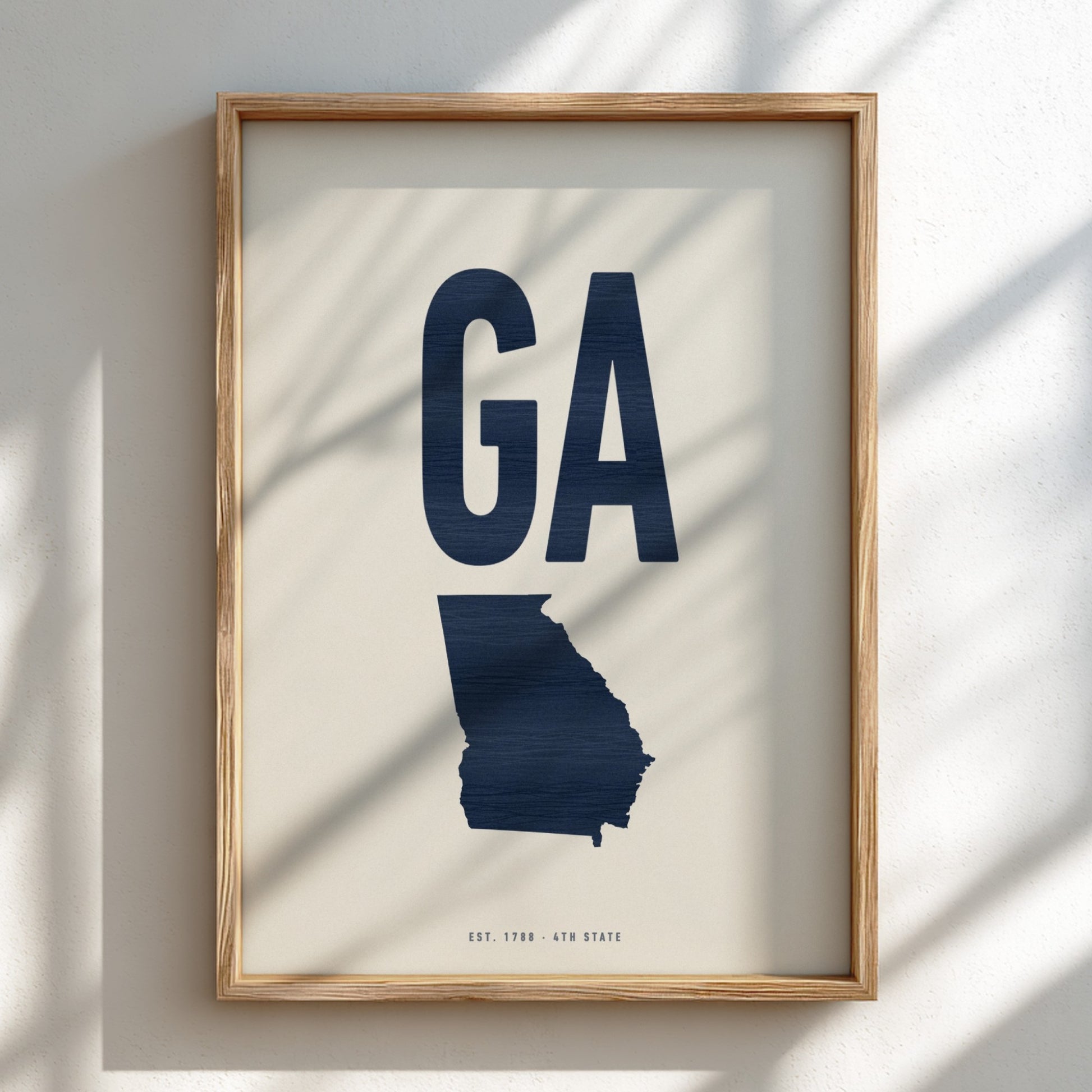 Framed artwork of the state of Georgia with 'GA' on a light background
